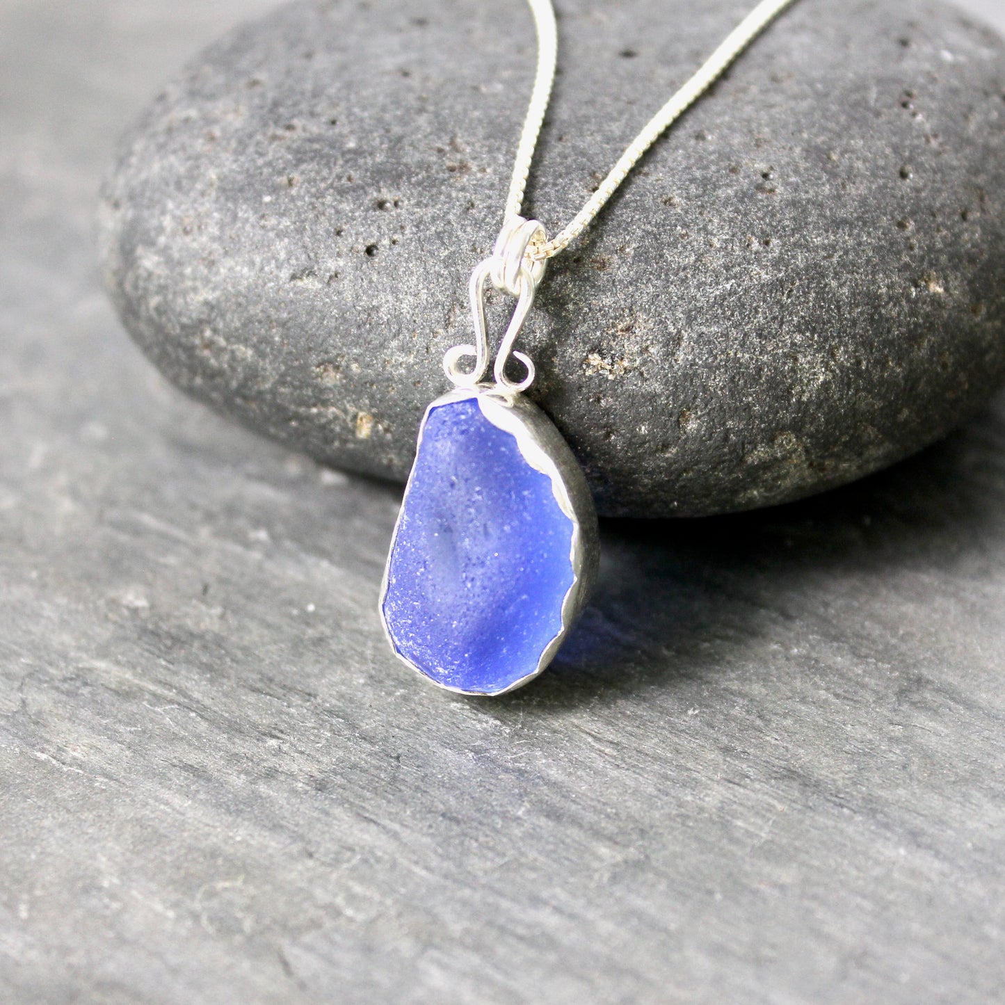 Sterling silver cobalt sea glass set in a fine and sterling silver bezel setting on a sterling silver chain.