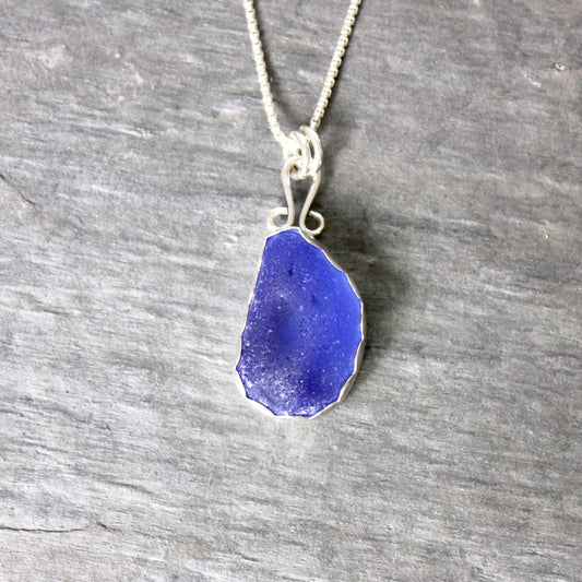 Sterling silver cobalt sea glass set in a fine and sterling silver bezel setting on a sterling silver chain.