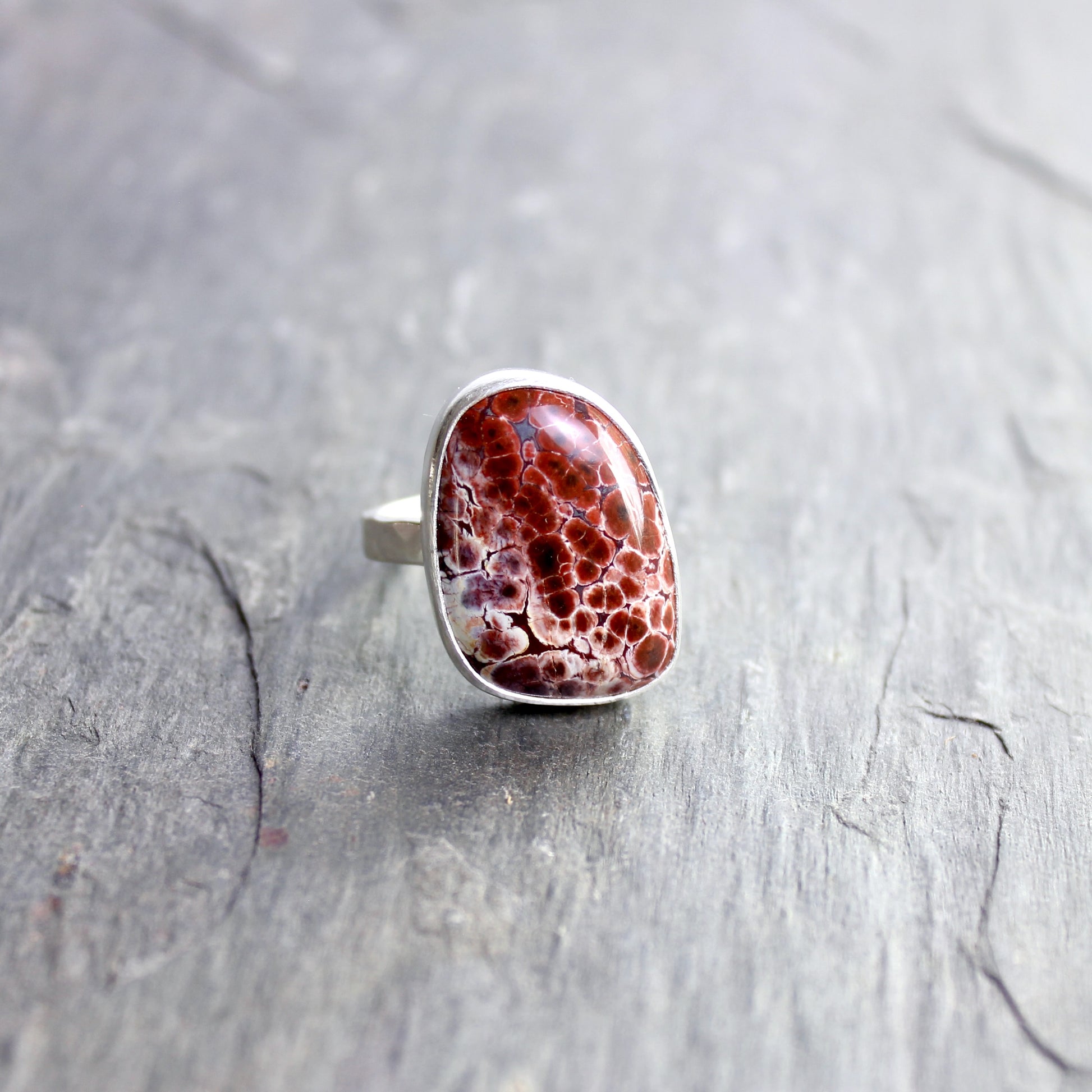 This pretty ring has a locally-sourced red Oregon orbicular jasper that is set in a fine and sterling silver bezel and on a sturdy silver hammered band. Handmade by Will Macy in Corvallis, OR.