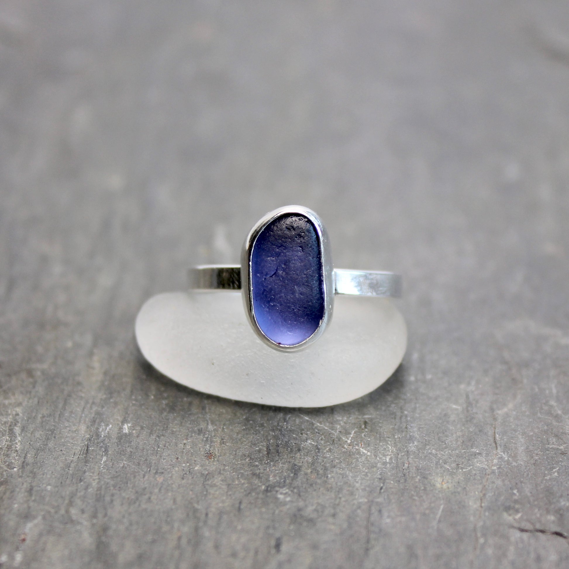 Silver ring with a blue stone on a gray surface