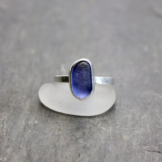 Silver ring with a blue stone on a gray surface