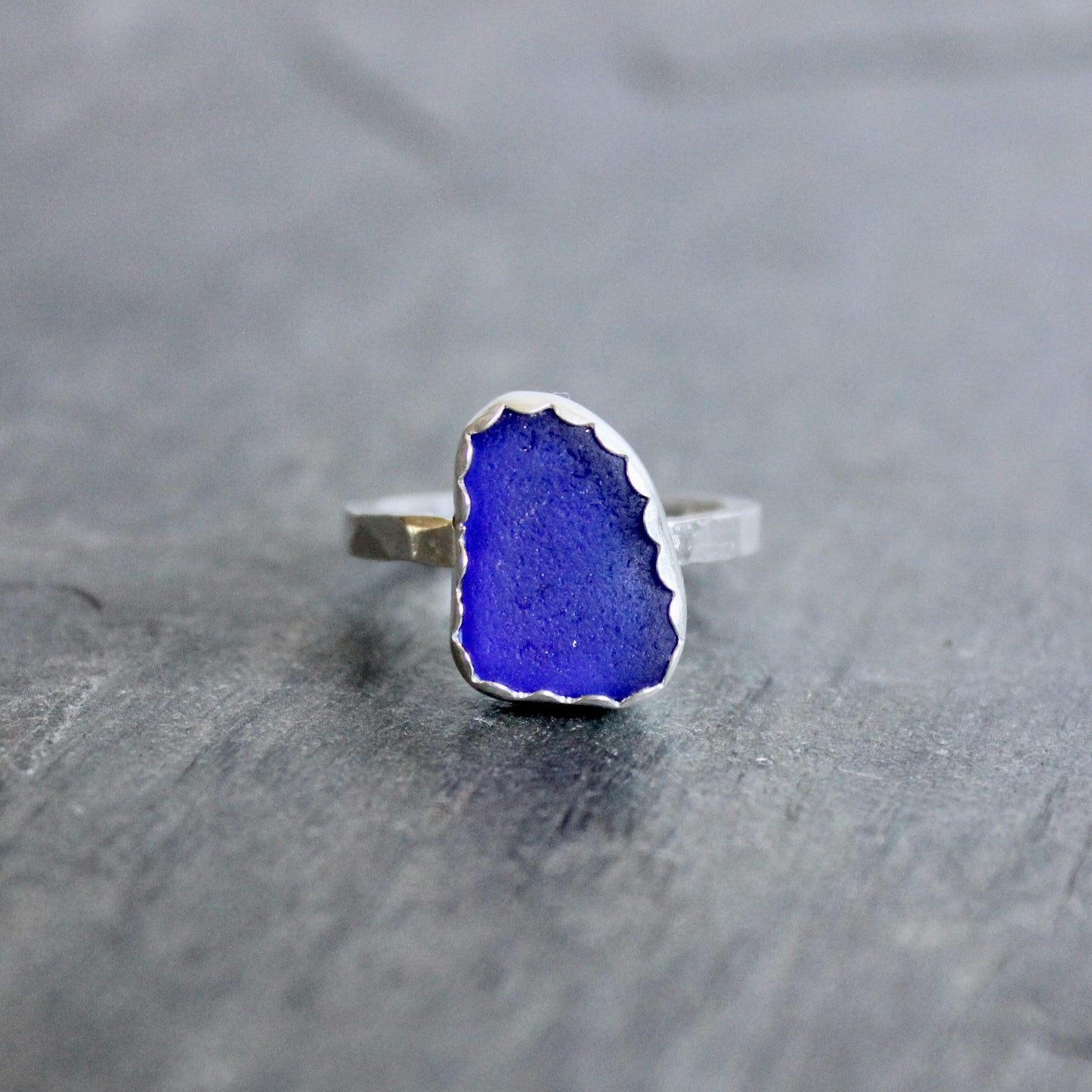 Ring with a blue stone on a gray surface