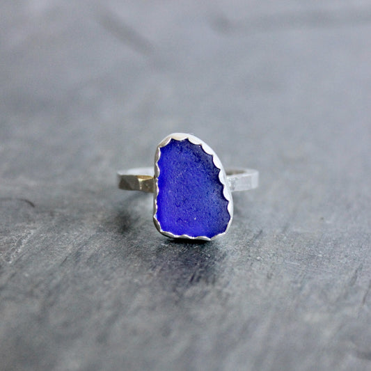 Ring with a blue stone on a gray surface