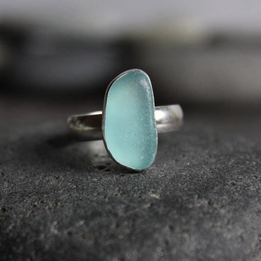 This is an aqua blue piece of sea glass in a fine and sterling silver bezel setting with a sturdy silver band.  Size 8 1/2