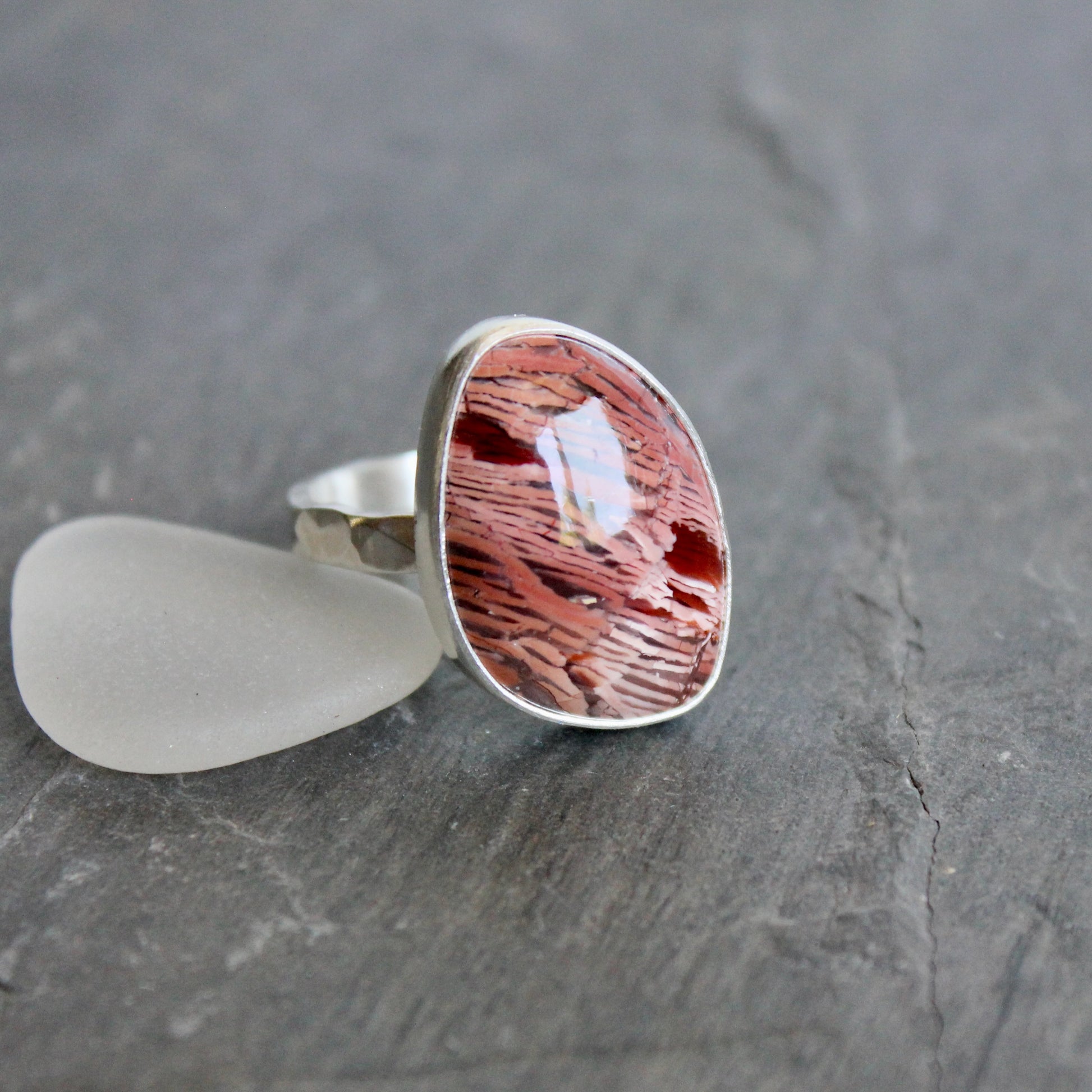 This large ring has a freeform rattlesnake jasper or Howardite cabochon that is set in a fine and sterling silver bezel setting on a sturdy hammered band. Size 11 3/4 Handmade by Will Macy in Corvallis, Oregon.