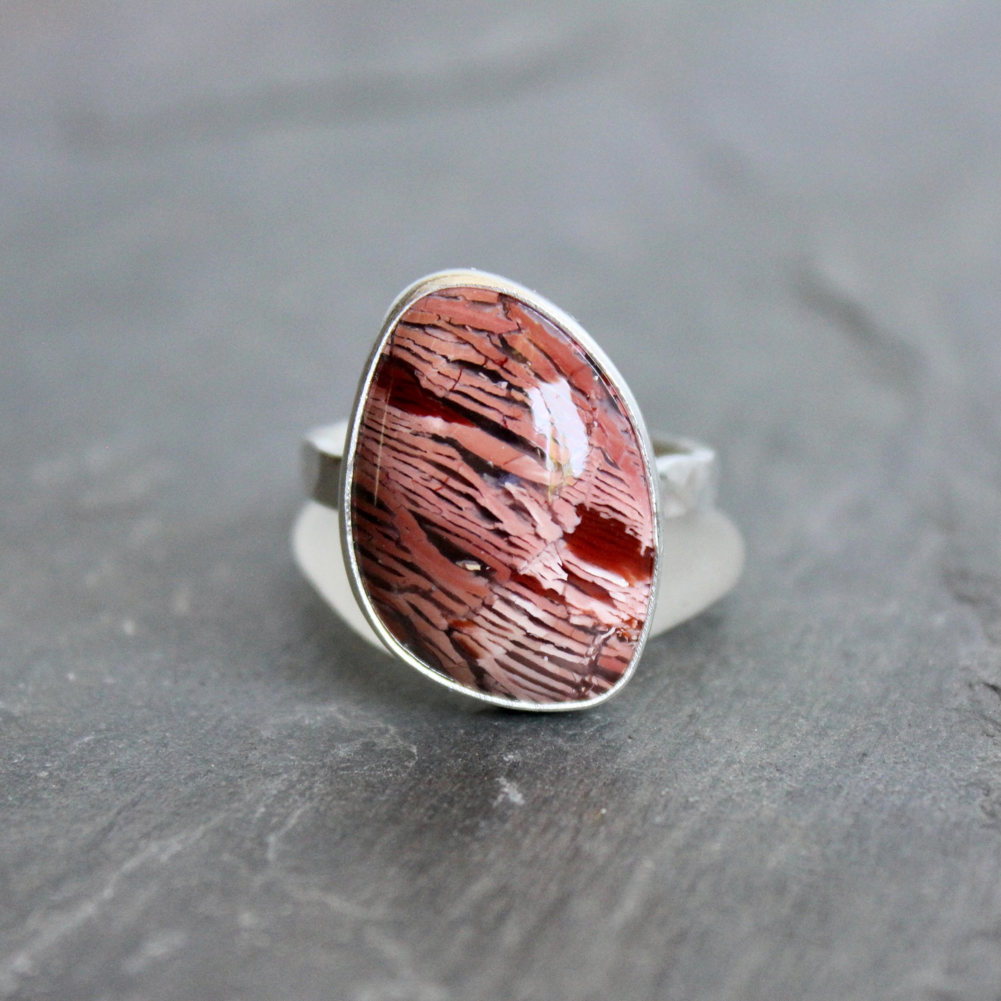 This large ring has a freeform rattlesnake jasper or Howardite cabochon that is set in a fine and sterling silver bezel setting on a sturdy hammered band. Size 11 3/4 Handmade by Will Macy in Corvallis, Oregon.