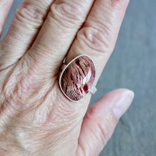 This large ring has a freeform rattlesnake jasper or Howardite cabochon that is set in a fine and sterling silver bezel setting on a sturdy hammered band. Size 11 3/4 Handmade by Will Macy in Corvallis, Oregon.