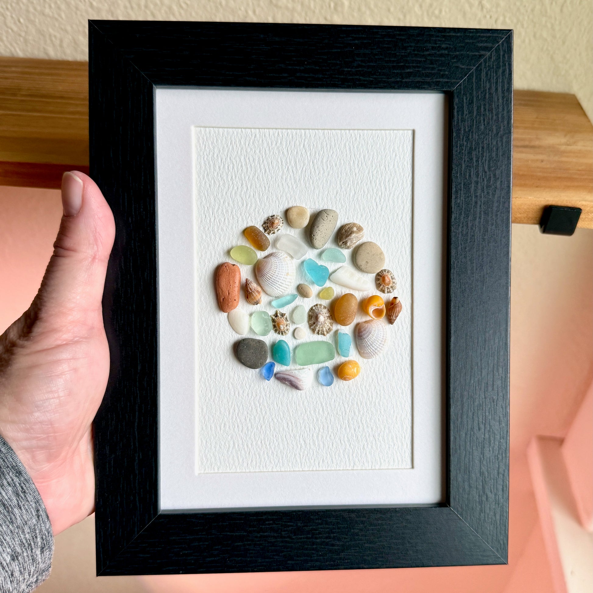 Framed artwork with colorful stones on a white background