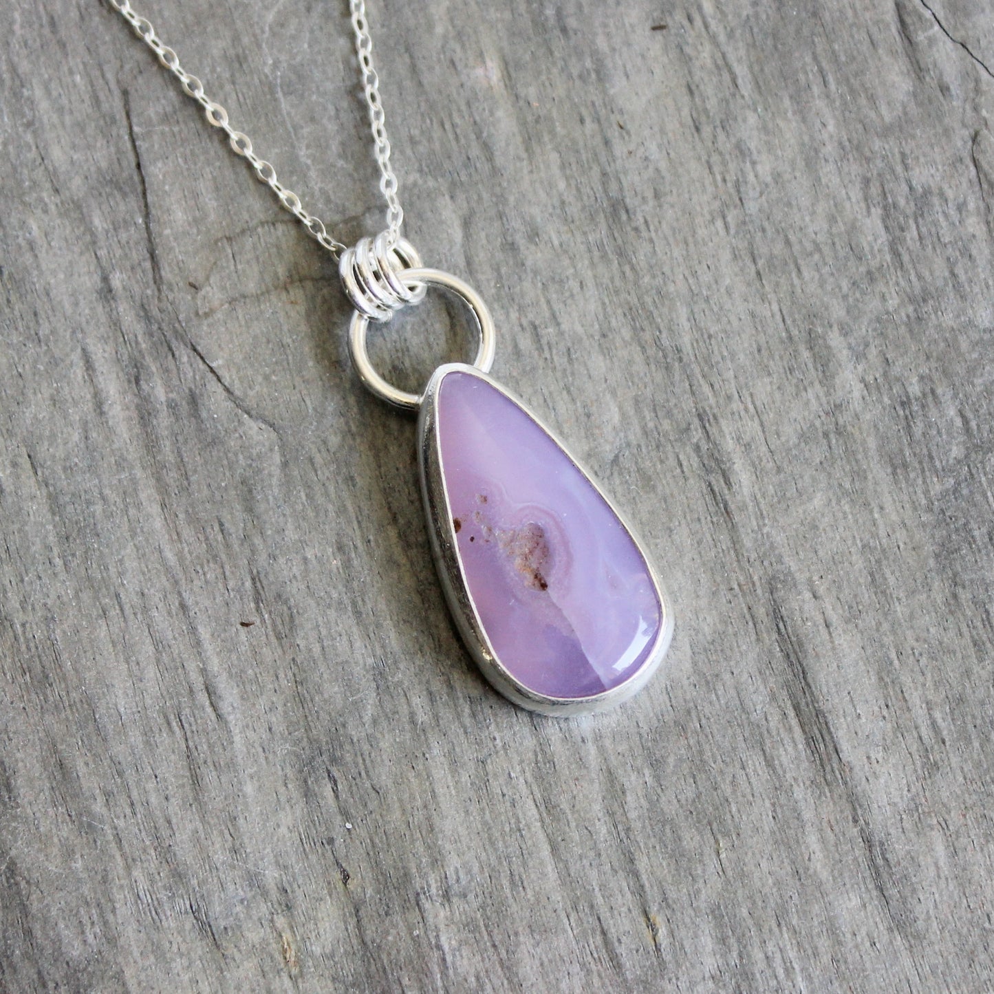 This pendant has a rare holley blue agate cabochon that is set in a fine and sterling silver bezel setting on a sturdy silver chain. Handmade by Will Macy in Corvallis, Oregon.