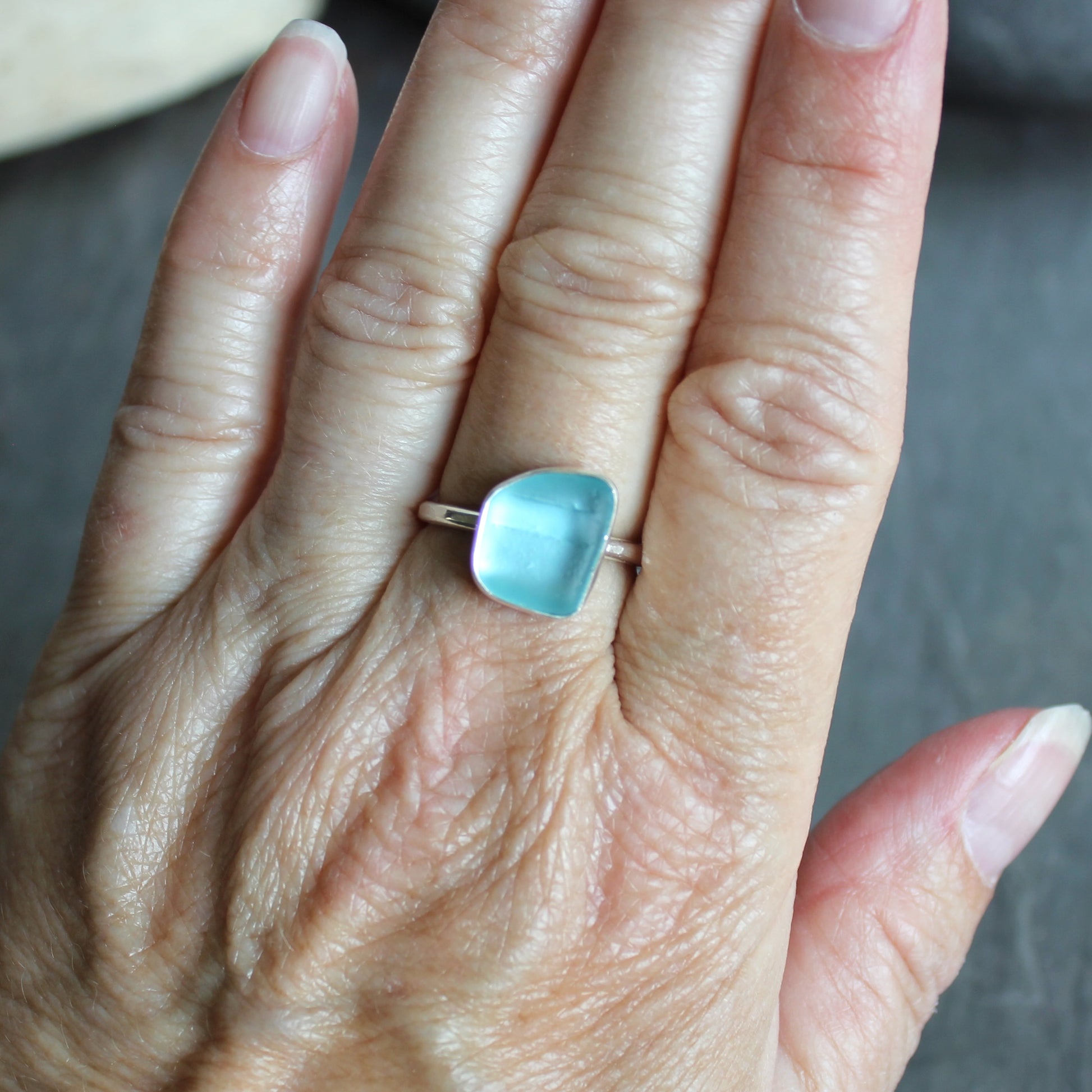 This ring has an aqua turquoise blue piece of sea glass that is set in a fine and sterling silver bezel setting on a sturdy hammered band. Size 8 3/4 Handmade by Barb Macy in Corvallis, Oregon.
