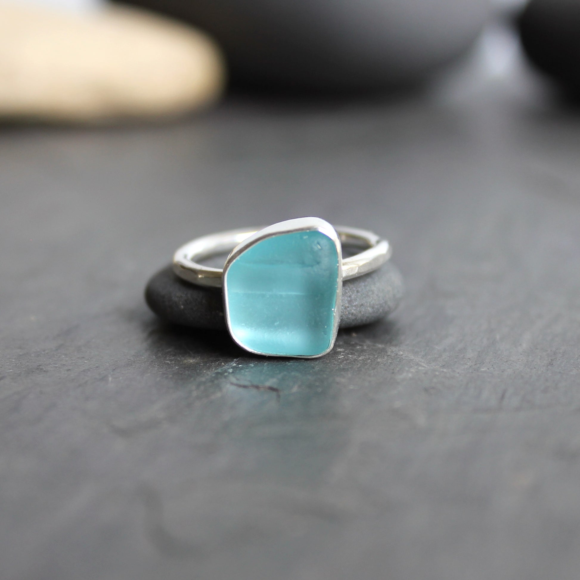 This ring has an aqua turquoise blue piece of sea glass that is set in a fine and sterling silver bezel setting on a sturdy hammered band. Size 8 3/4 Handmade by Barb Macy in Corvallis, Oregon.