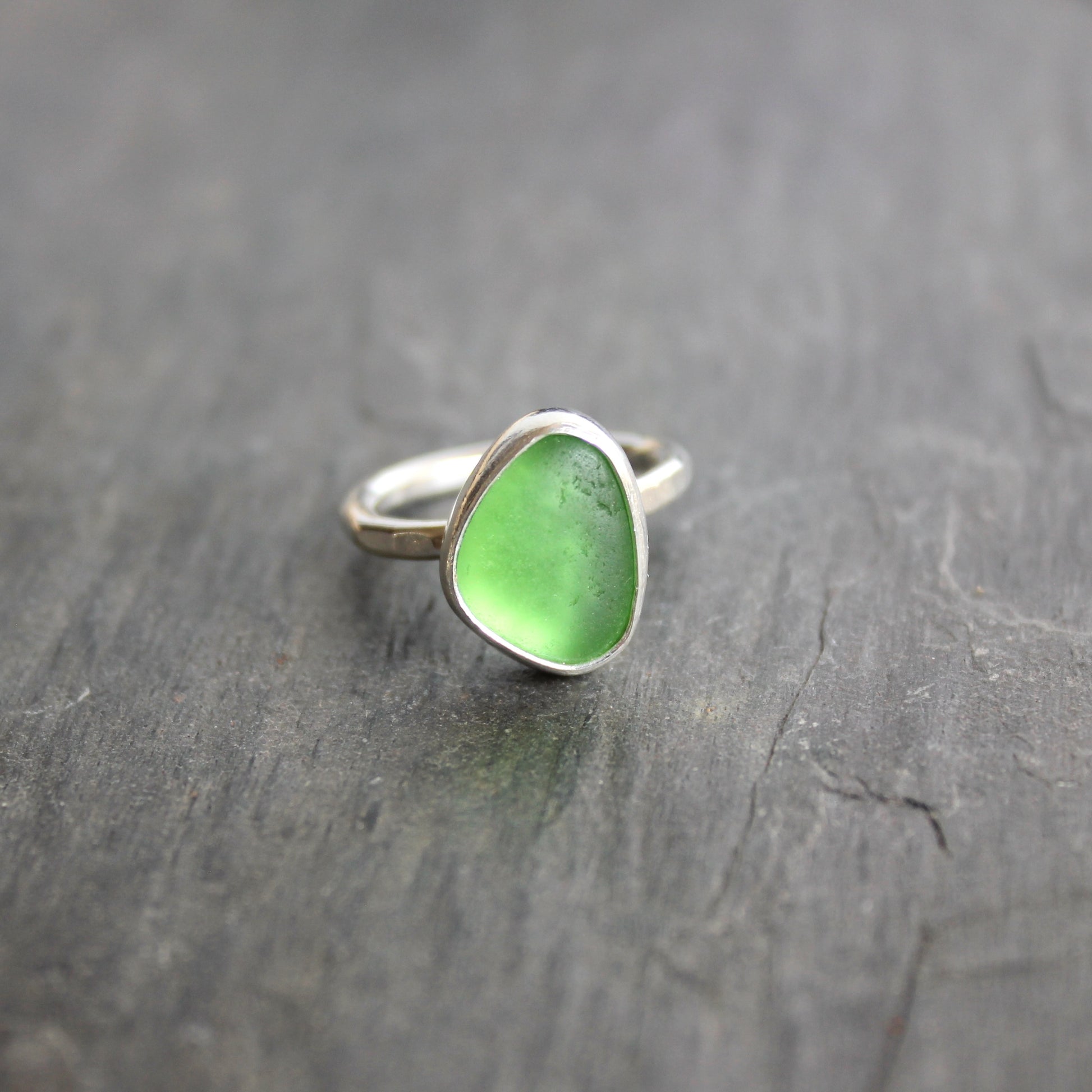 This ring has a small piece of bright green sea glass that is set in a fine and sterling silver bezel setting on a sturdy silver band. Size 5. Handmade by Barb Macy in Corvallis, OR.