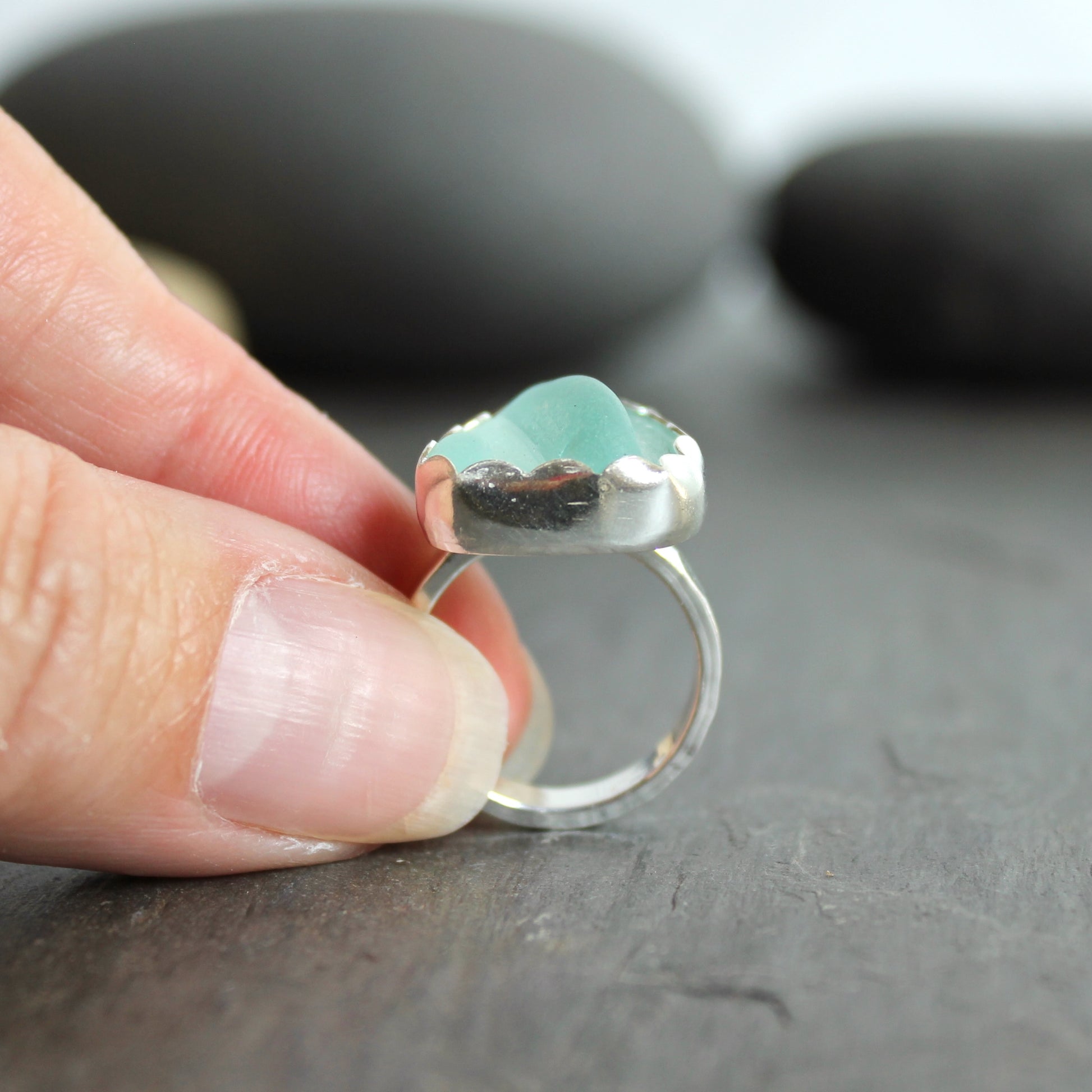 This statement ring has a pale aqua blue piece of sea glass that is set in a fine and sterling silver scalloped bezel on a sturdy hammered band. This piece is actually from a bottle neck. Handmade by Barb Macy in Corvallis, OR. Size 5 