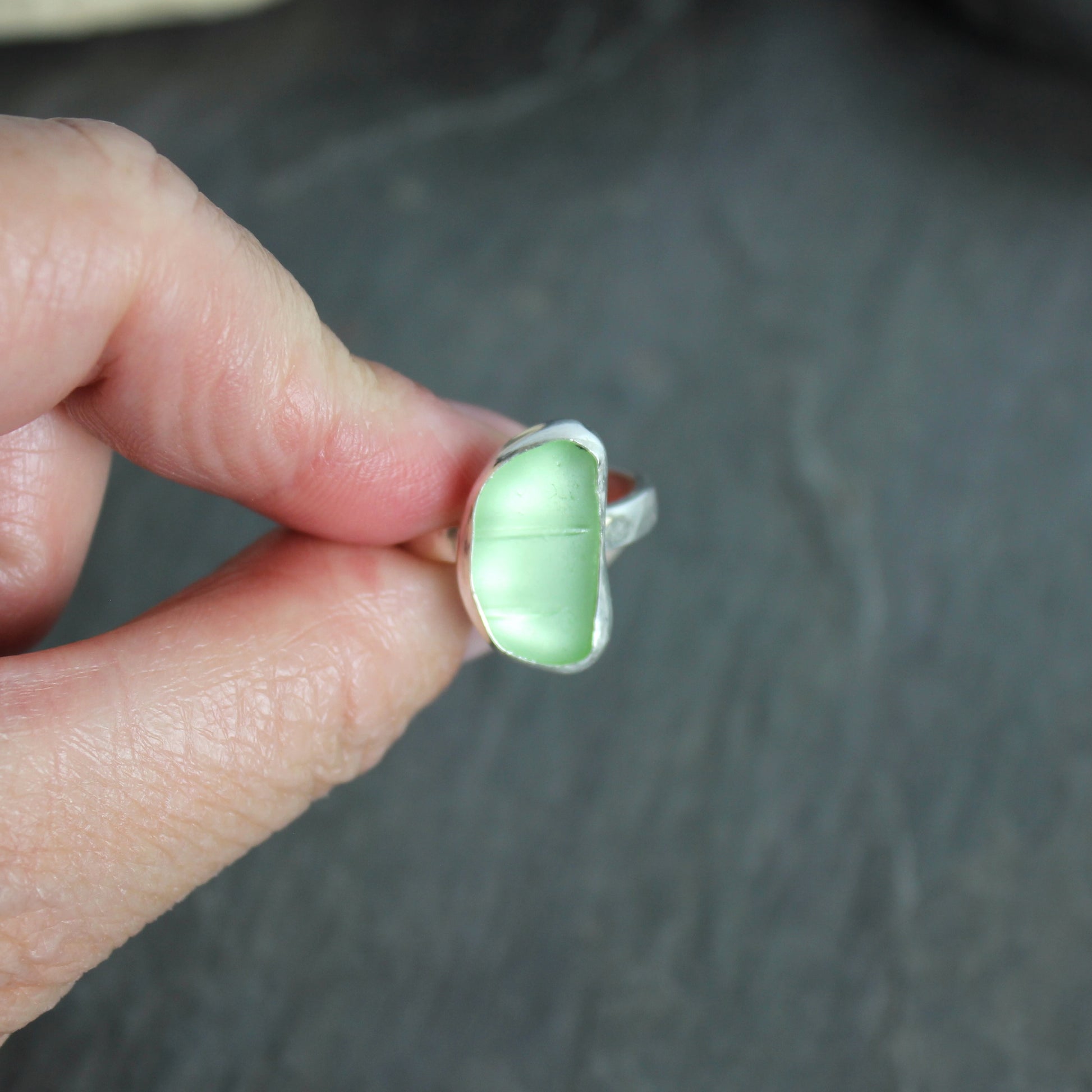 This ring has a pale yellow piece of UV uranium sea glass that is set in a fine and sterling silver bezel setting on a sturdy hammered band. Size 7 3/4 Handmade by Barb Macy in Corvallis, Oregon.