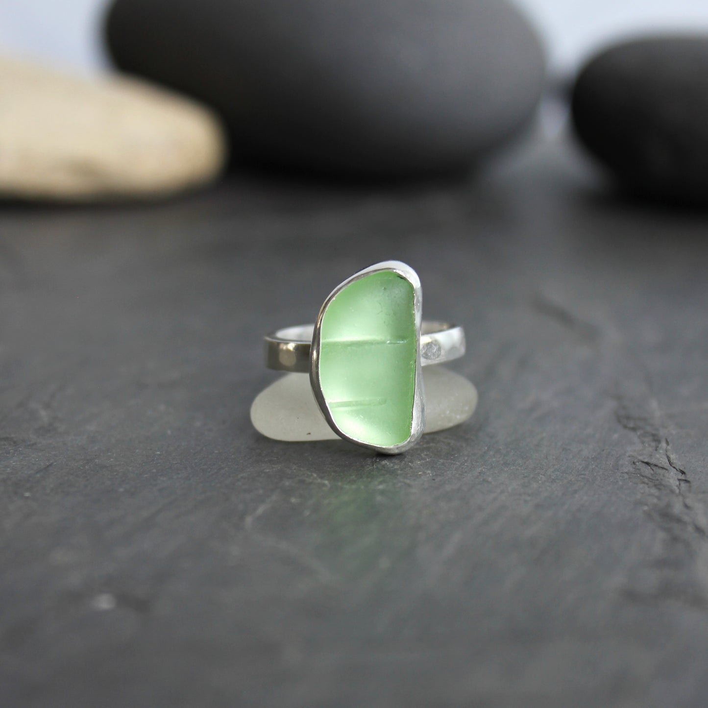 This ring has a pale yellow piece of UV uranium sea glass that is set in a fine and sterling silver bezel setting on a sturdy hammered band. Size 7 3/4 Handmade by Barb Macy in Corvallis, Oregon.