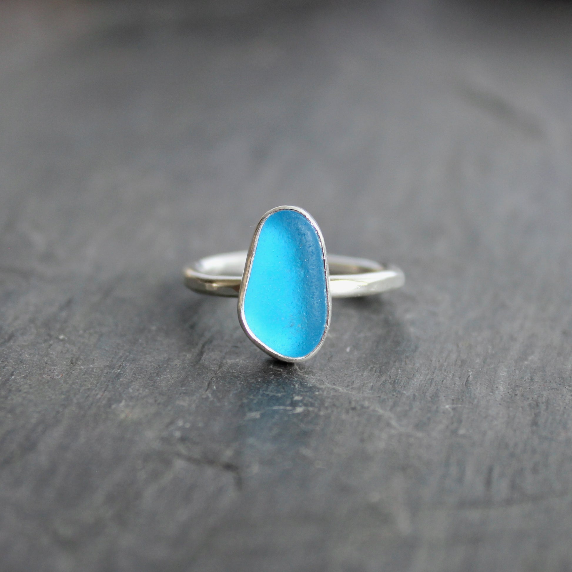 This ring has a piece of electric turquoise blue sea glass that is set in a fine and sterling silver bezel setting on a sturdy silver band. Size 7 3/4 Handmade by Barb Macy in Corvallis, OR.