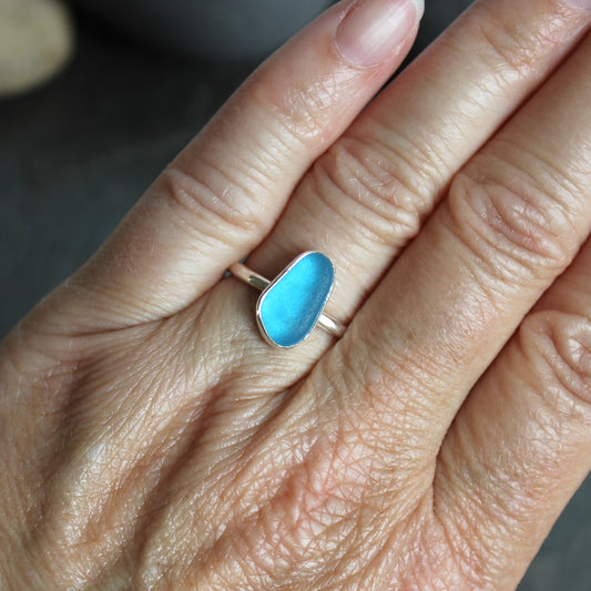 This ring has a piece of electric turquoise blue sea glass that is set in a fine and sterling silver bezel setting on a sturdy silver band. Size 7 3/4 Handmade by Barb Macy in Corvallis, OR.