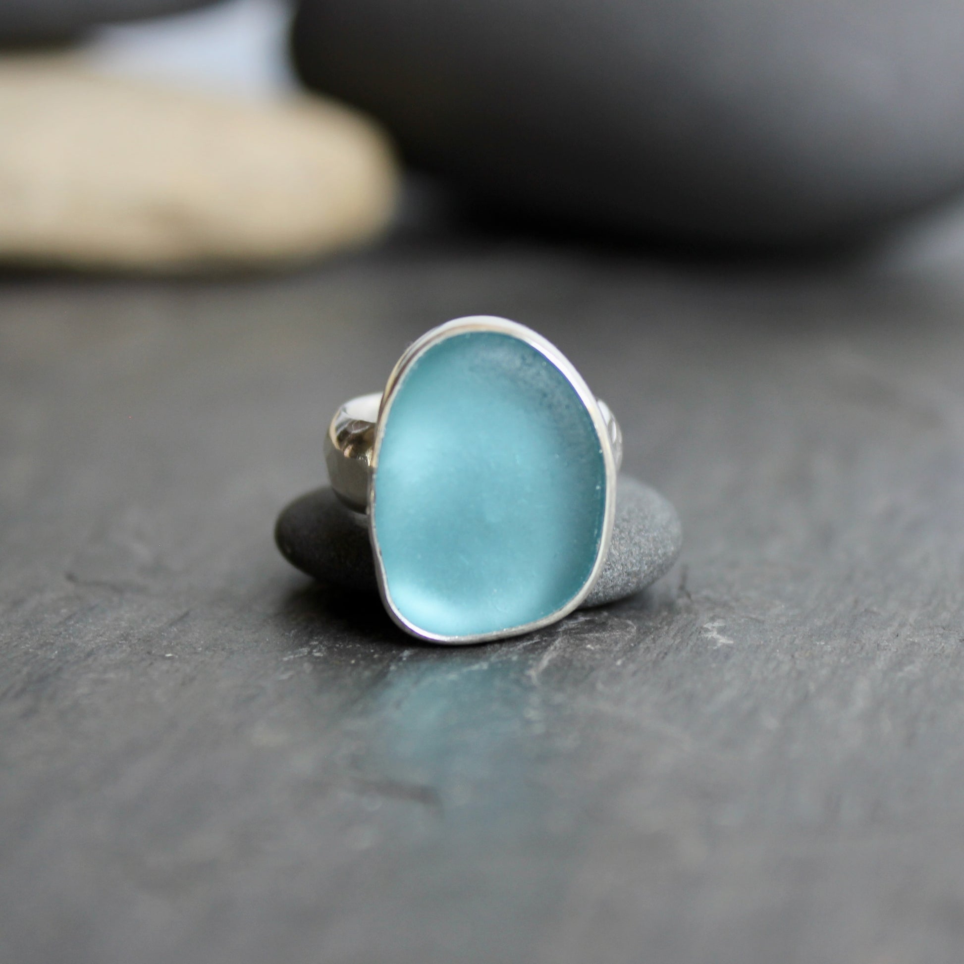 This ring has a large piece of aqua turquoise blue sea glass that is set in a fine and sterling silver bezel setting on a sturdy wide hammered band.  Size 4 1/2 Handmade by Barb Macy in Corvallis, Oregon.