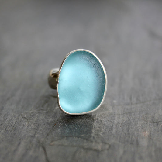 This ring has a large piece of aqua turquoise blue sea glass that is set in a fine and sterling silver bezel setting on a sturdy wide hammered band.  Size 4 1/2 Handmade by Barb Macy in Corvallis, Oregon.