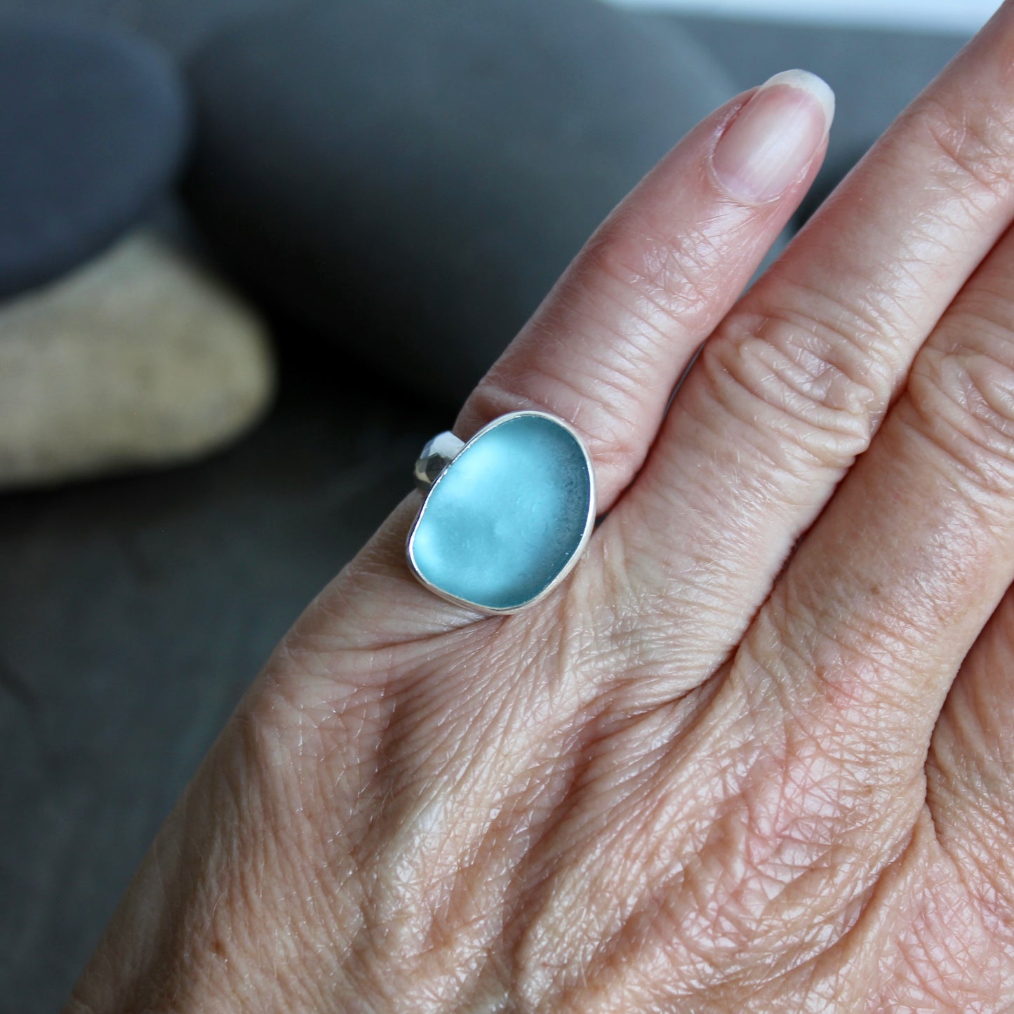 This ring has a large piece of aqua turquoise blue sea glass that is set in a fine and sterling silver bezel setting on a sturdy wide hammered band.  Size 4 1/2 Handmade by Barb Macy in Corvallis, Oregon.