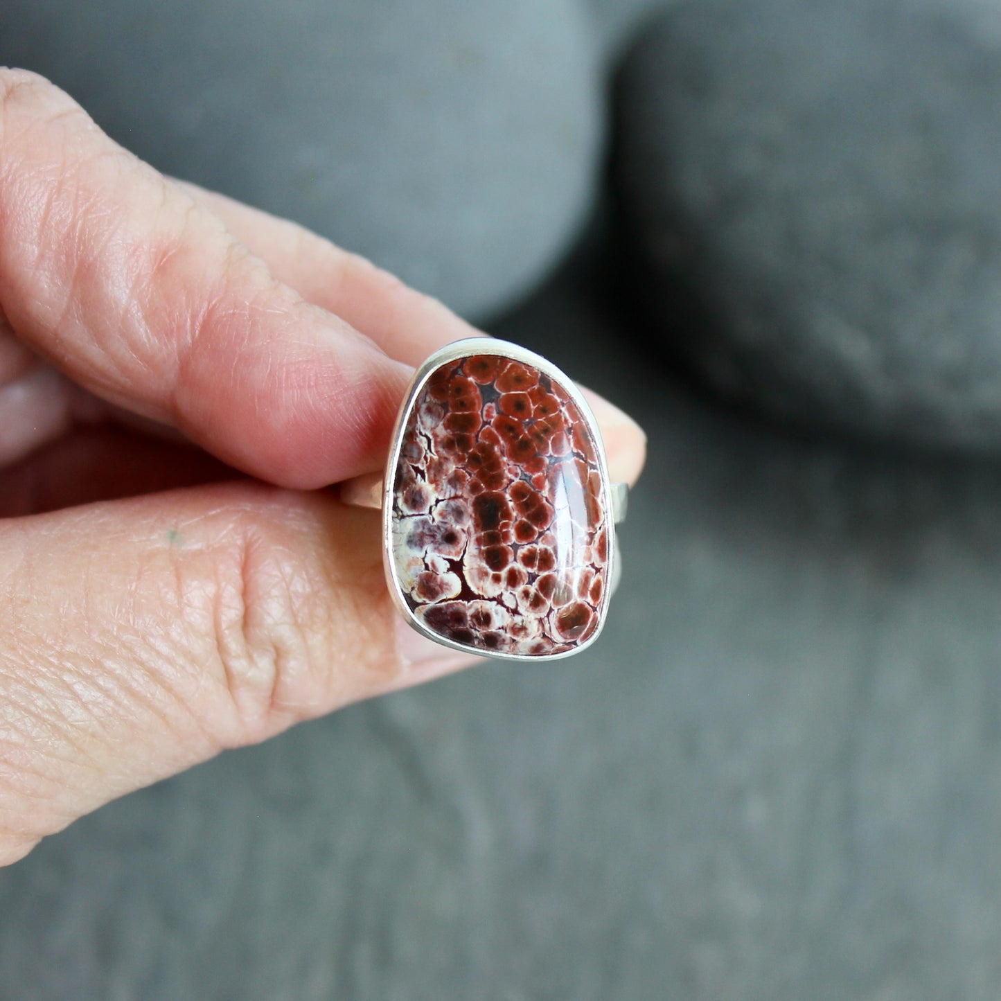 This pretty ring has a locally-sourced red Oregon orbicular jasper that is set in a fine and sterling silver bezel and on a sturdy silver hammered band. Handmade by Will Macy in Corvallis, OR.