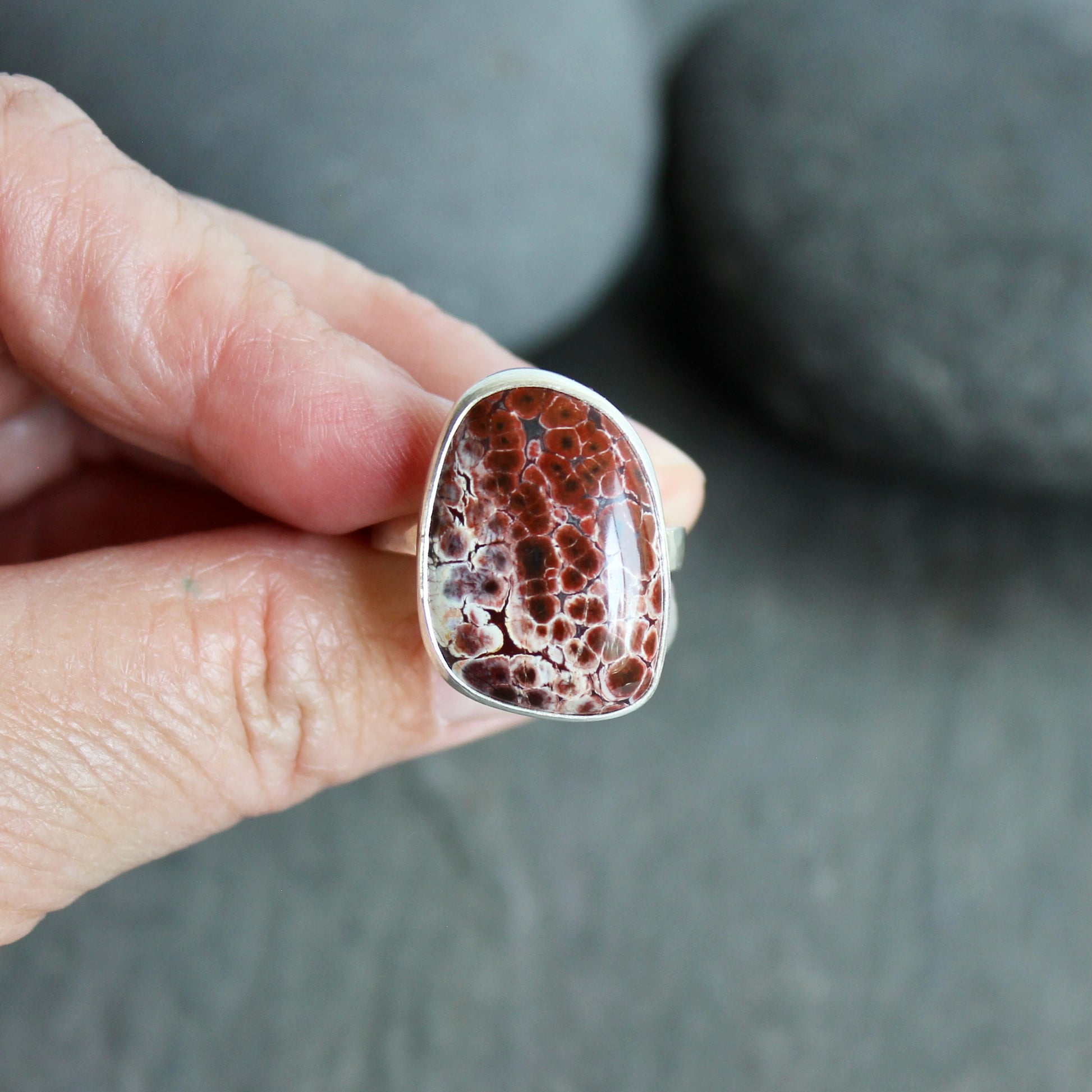 This pretty ring has a locally-sourced red Oregon orbicular jasper that is set in a fine and sterling silver bezel and on a sturdy silver hammered band. Handmade by Will Macy in Corvallis, OR.