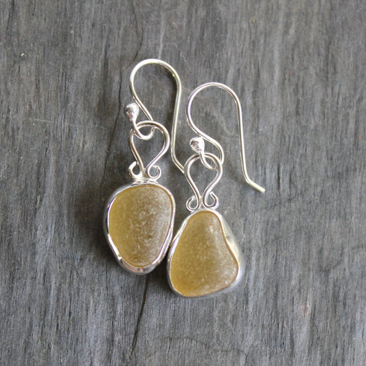 These earrings have two pieces of rare pale yellow sea glass from Massachusetts (USA)... set in sterling and fine silver and attached to handmade sterling silver ear wires. All of our sea glass is found and never altered in any way. All of our sea glass jewelry is handmade by Barb Macy in Corvallis, OR.
