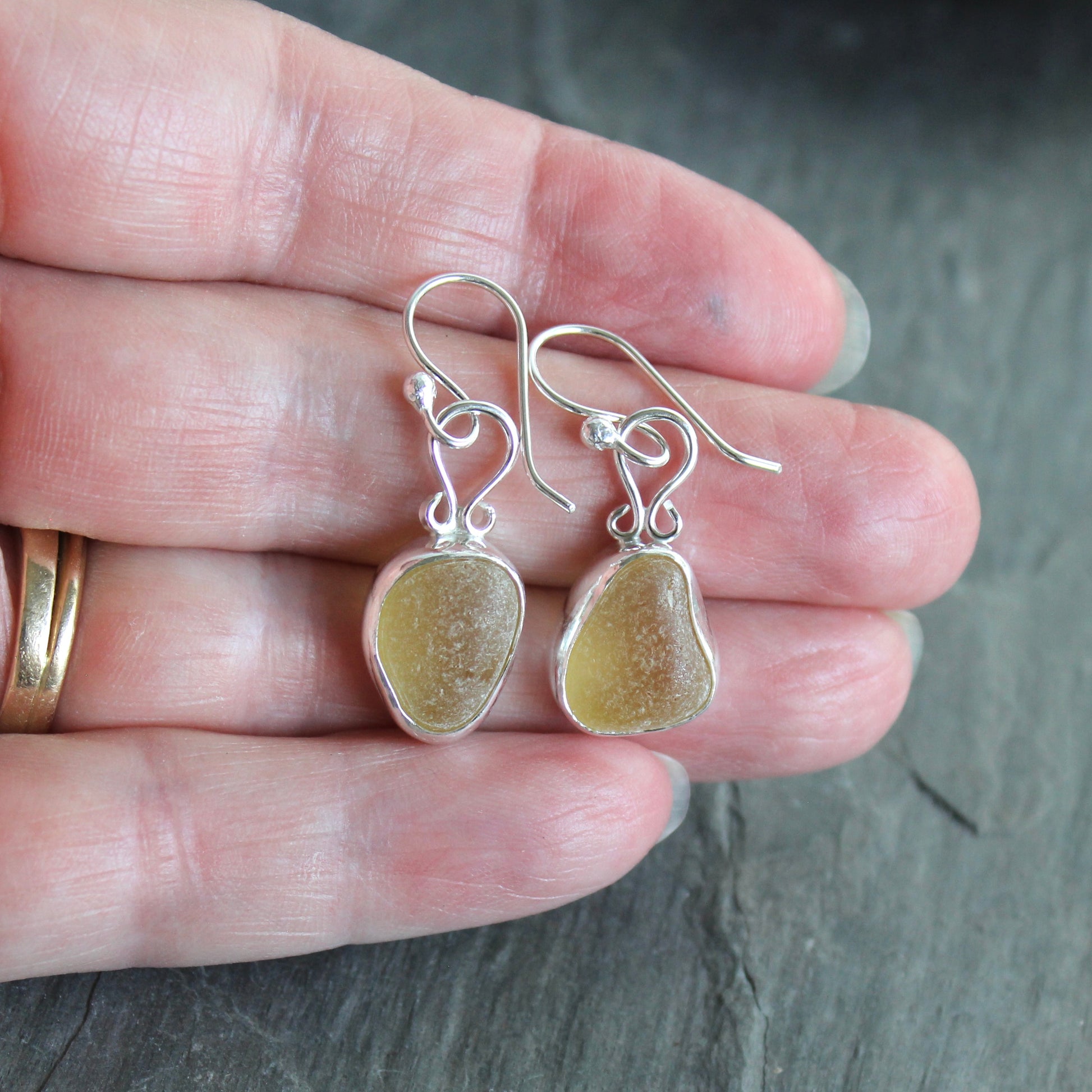 These earrings have two pieces of rare pale yellow sea glass from Massachusetts (USA)... set in sterling and fine silver and attached to handmade sterling silver ear wires. All of our sea glass is found and never altered in any way. All of our sea glass jewelry is handmade by Barb Macy in Corvallis, OR.
