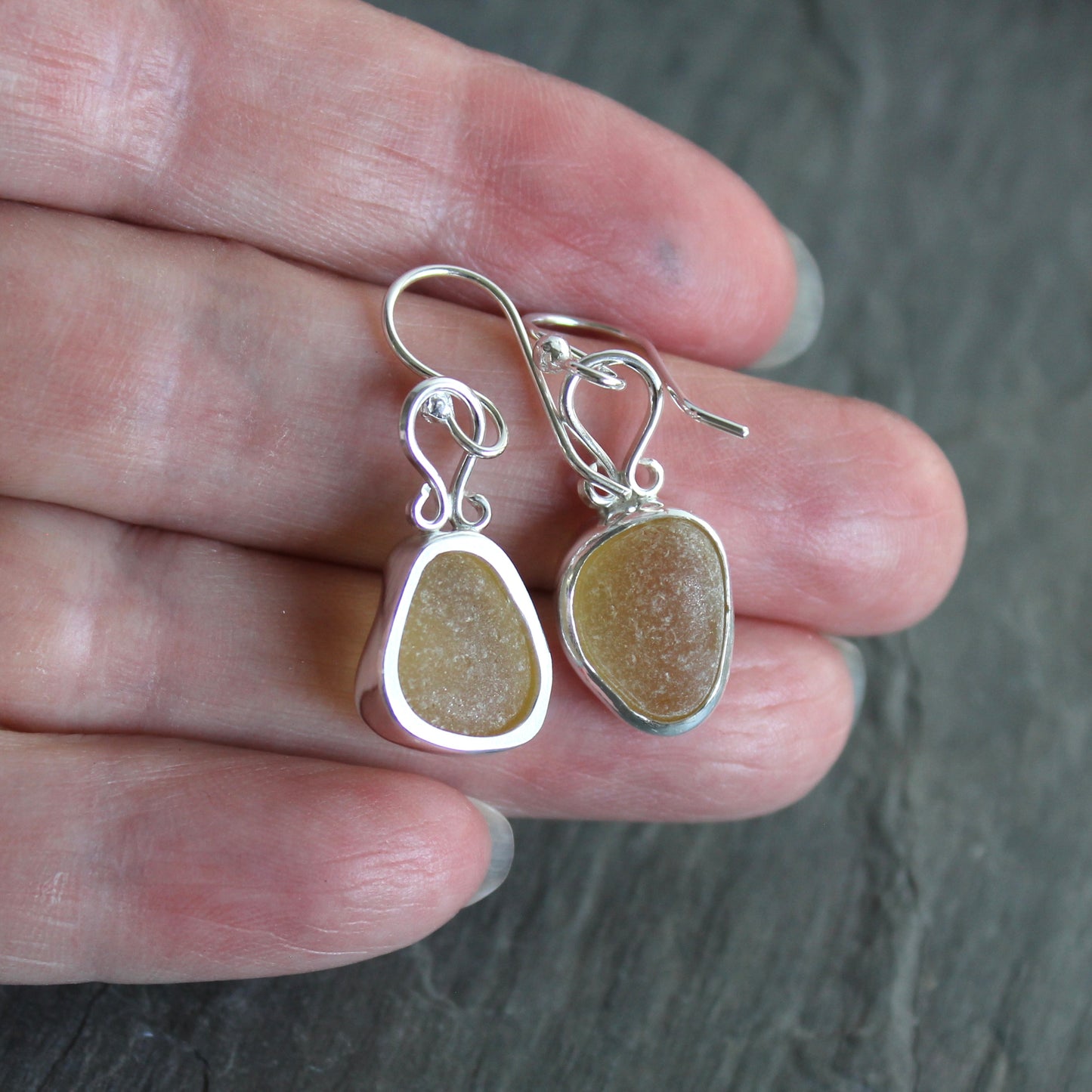 These earrings have two pieces of rare pale yellow sea glass from Massachusetts (USA)... set in sterling and fine silver and attached to handmade sterling silver ear wires. All of our sea glass is found and never altered in any way. All of our sea glass jewelry is handmade by Barb Macy in Corvallis, OR.
