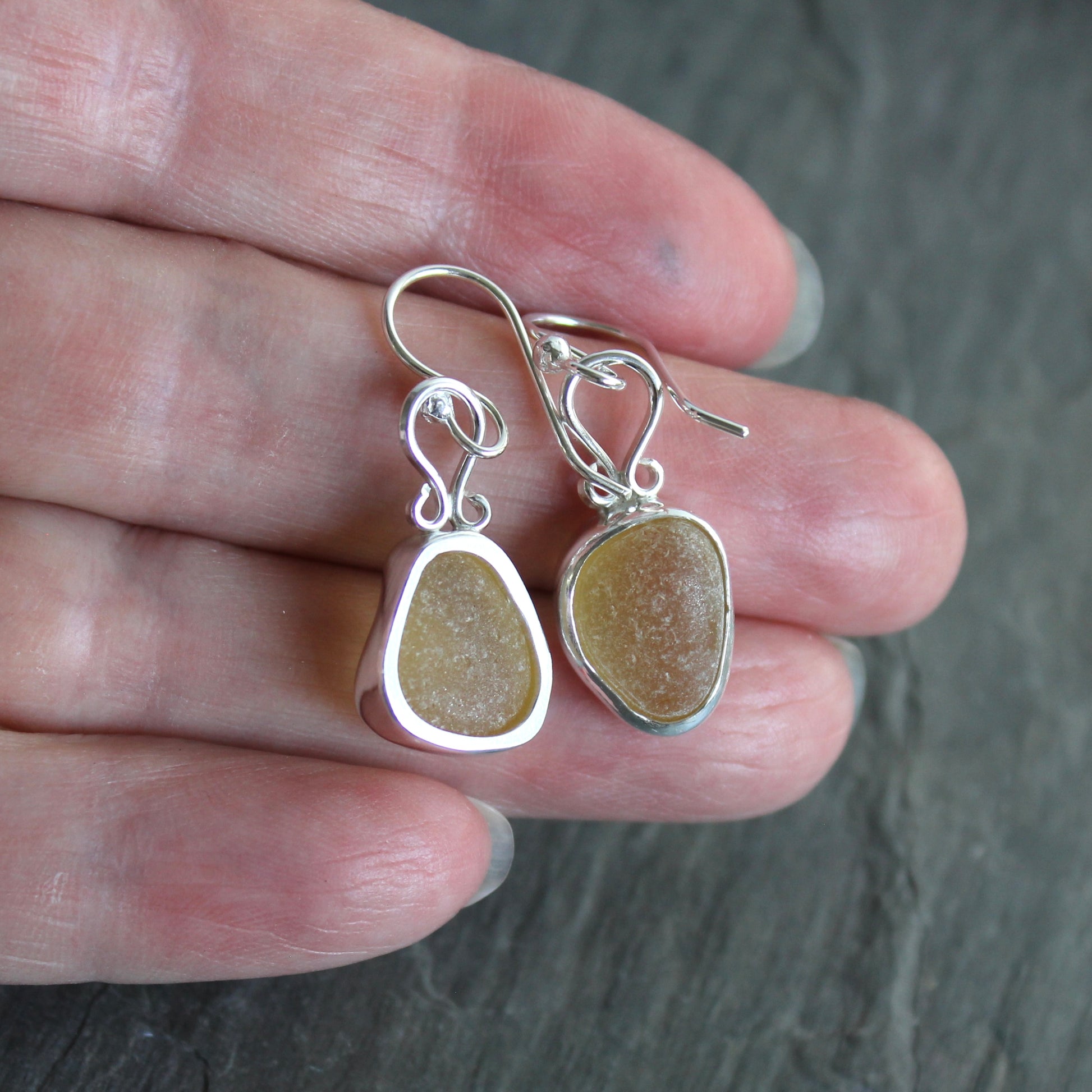 These earrings have two pieces of rare pale yellow sea glass from Massachusetts (USA)... set in sterling and fine silver and attached to handmade sterling silver ear wires. All of our sea glass is found and never altered in any way. All of our sea glass jewelry is handmade by Barb Macy in Corvallis, OR.

