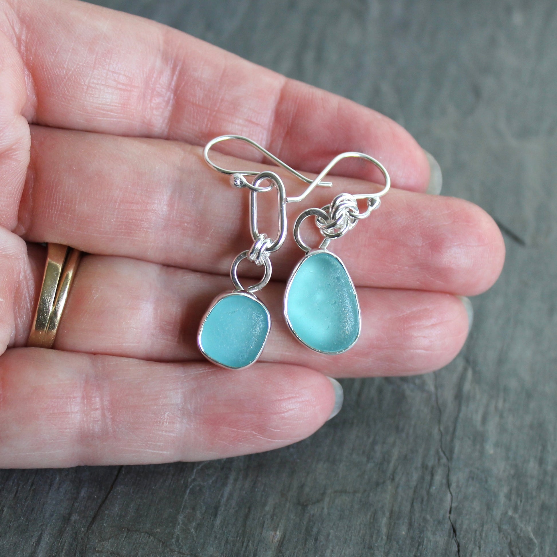 Mismatched Turquoise Blue Sea Glass dangly earrings. They are set in a sterling and fine silver bezel setting and are on sterling silver ear wires.
