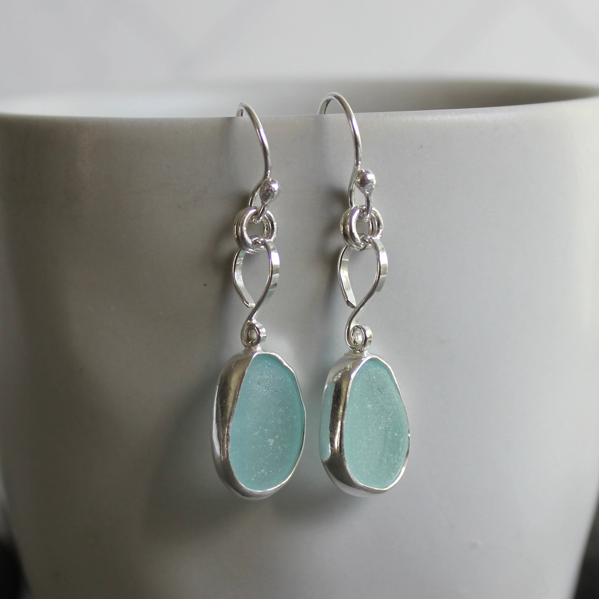 For these pretty earrings, I used 2 pieces of pale blue sea glass from Japan that are set in a sterling & fine silver bezel setting and are on sterling silver ear wires. All of our sea glass is found and never altered in any way. This item was handmade by Barb Macy in Corvallis, OR.
