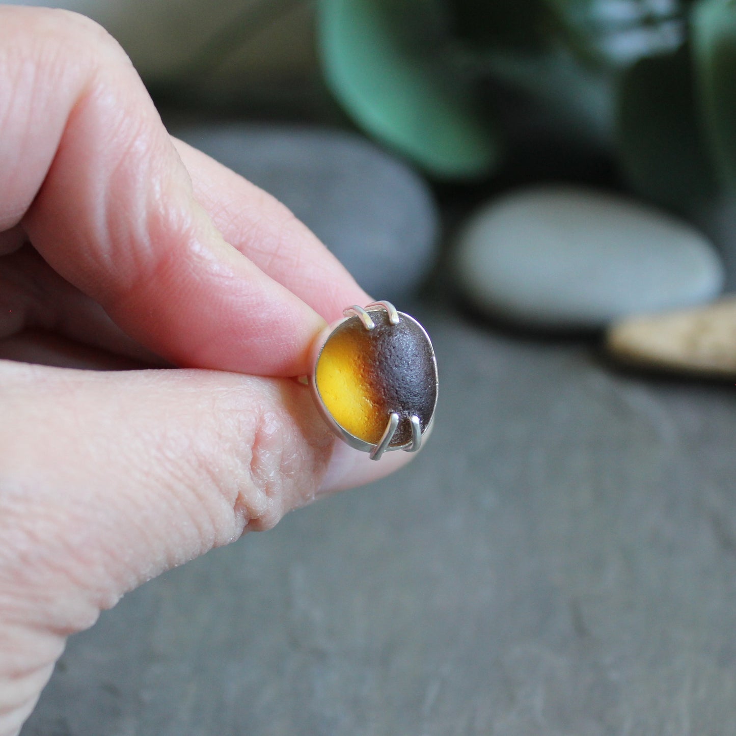 This ring has a piece of amber brown Seaham (UK) sea glass that is set in a fine and sterling silver bezel and soldered to a sturdy sterling silver band.