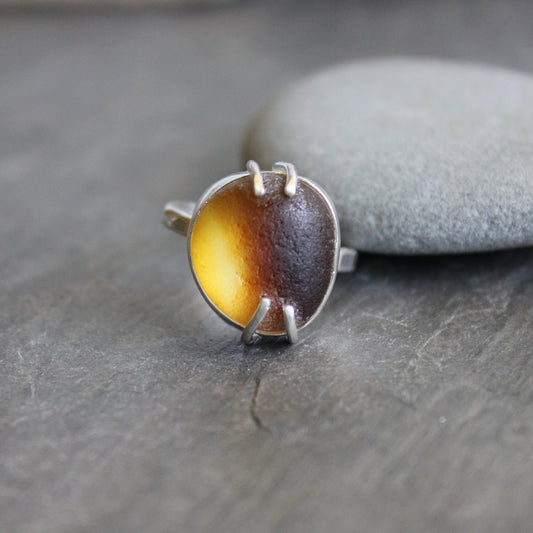 This ring has a piece of amber brown Seaham (UK) sea glass that is set in a fine and sterling silver bezel and soldered to a sturdy sterling silver band.