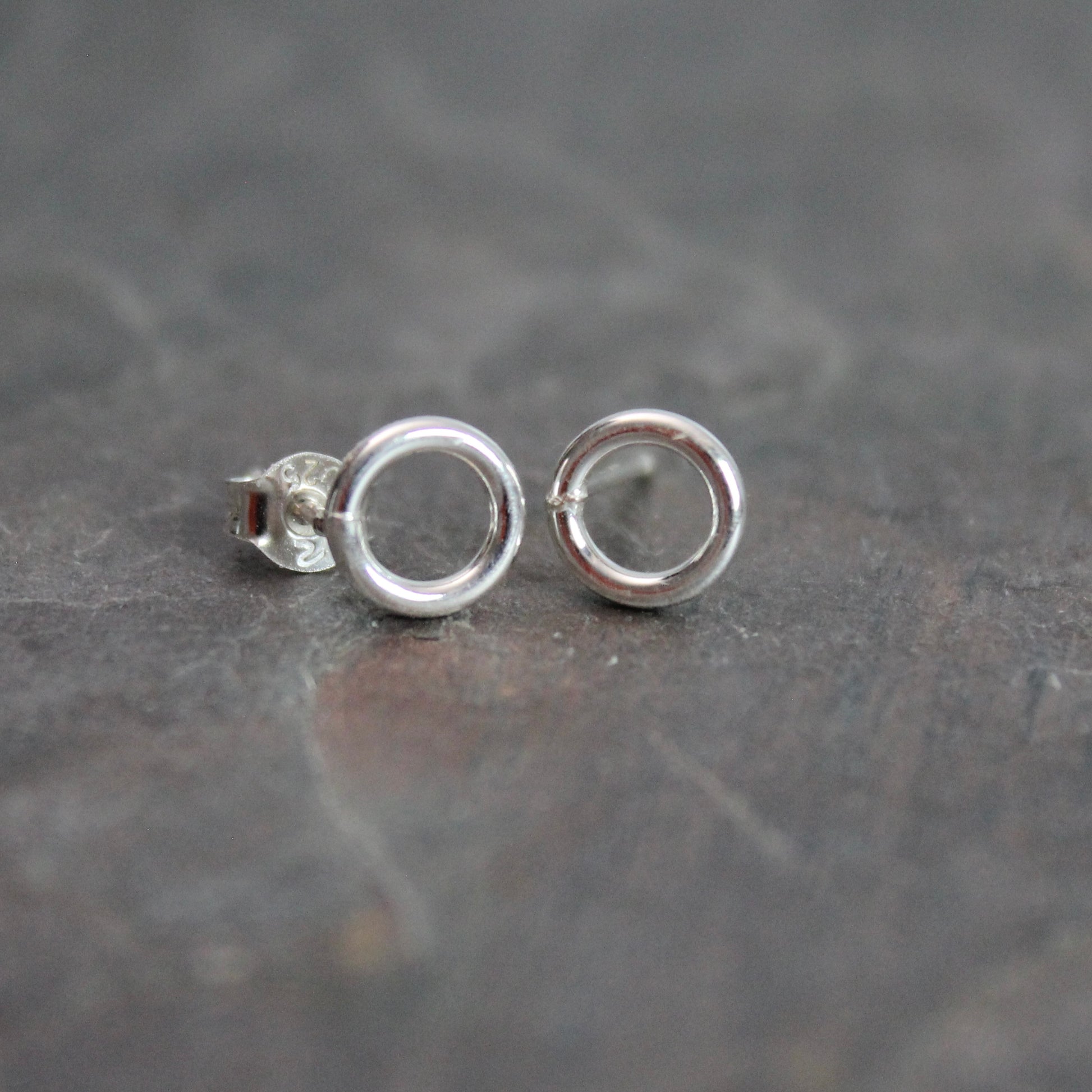 These cute little stud earrings have simple 8-10mm jump rings solders onto sterling silver posts and completed with ear nuts. Handmade by Barb Macy in Corvallis, Oregon.
