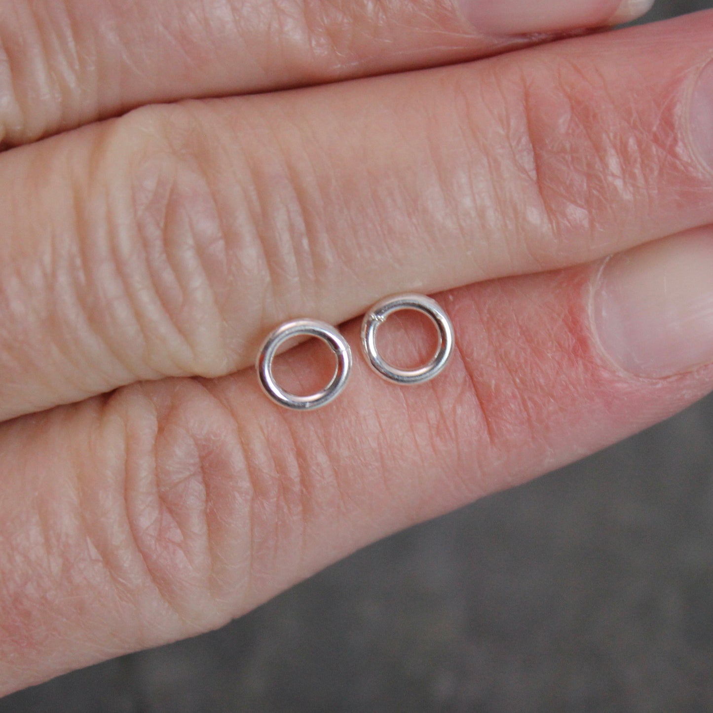 These cute little stud earrings have simple 8-10mm jump rings solders onto sterling silver posts and completed with ear nuts. Handmade by Barb Macy in Corvallis, Oregon.