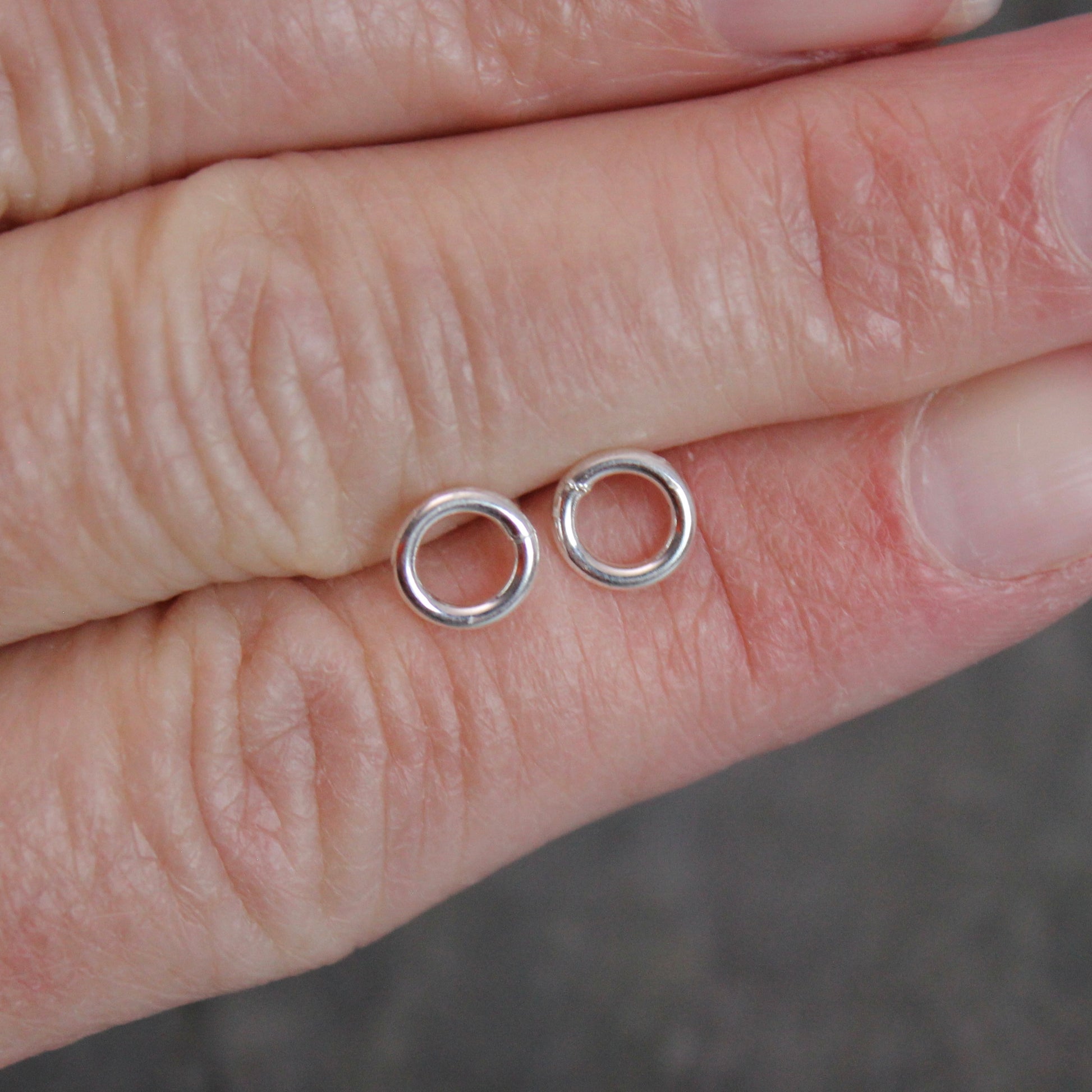 These cute little stud earrings have simple 8-10mm jump rings solders onto sterling silver posts and completed with ear nuts. Handmade by Barb Macy in Corvallis, Oregon.
