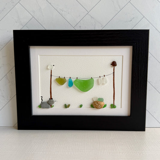 Framed artwork with sea glass pieces on a white background