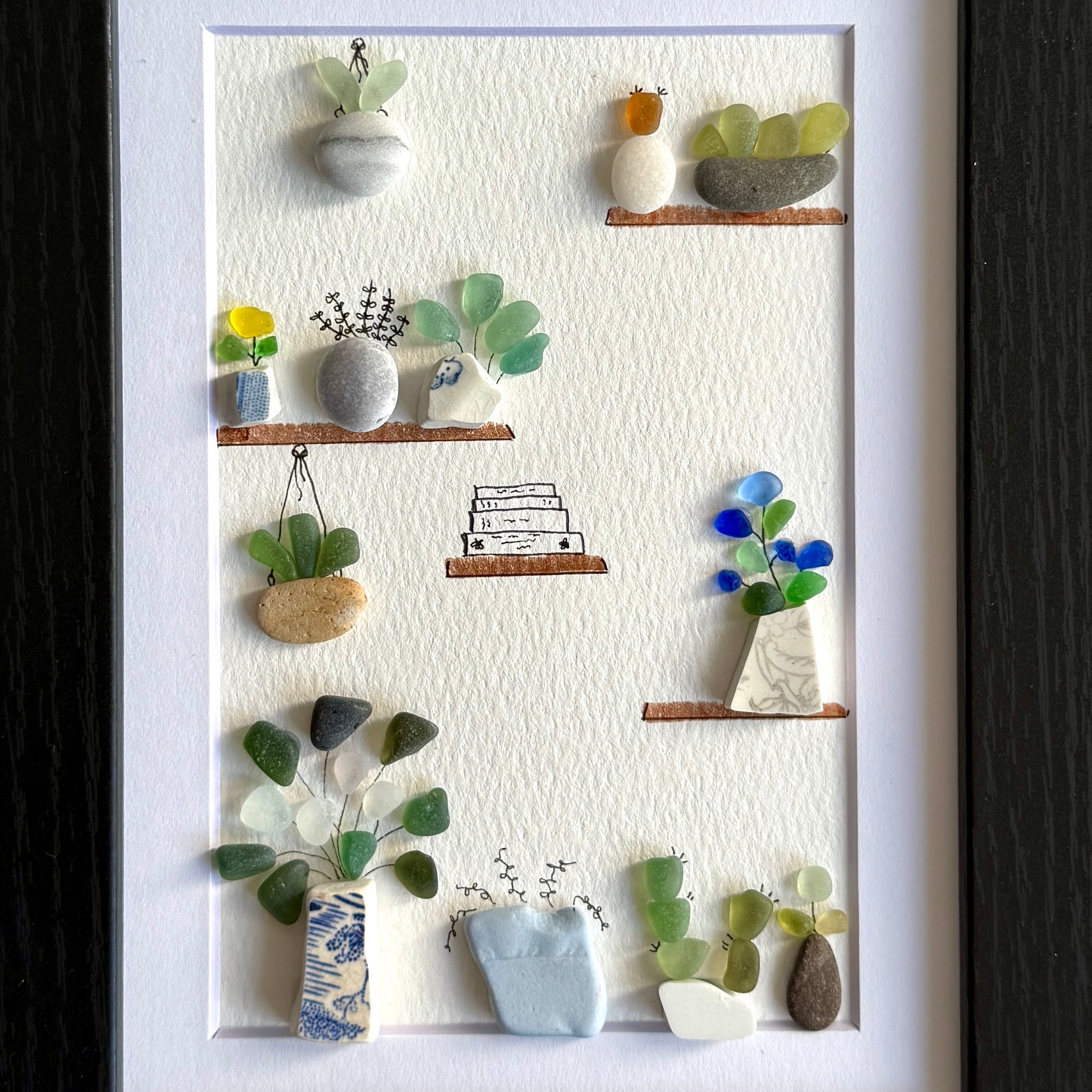 Decorative wall art with miniature plants and shelves on a white background
