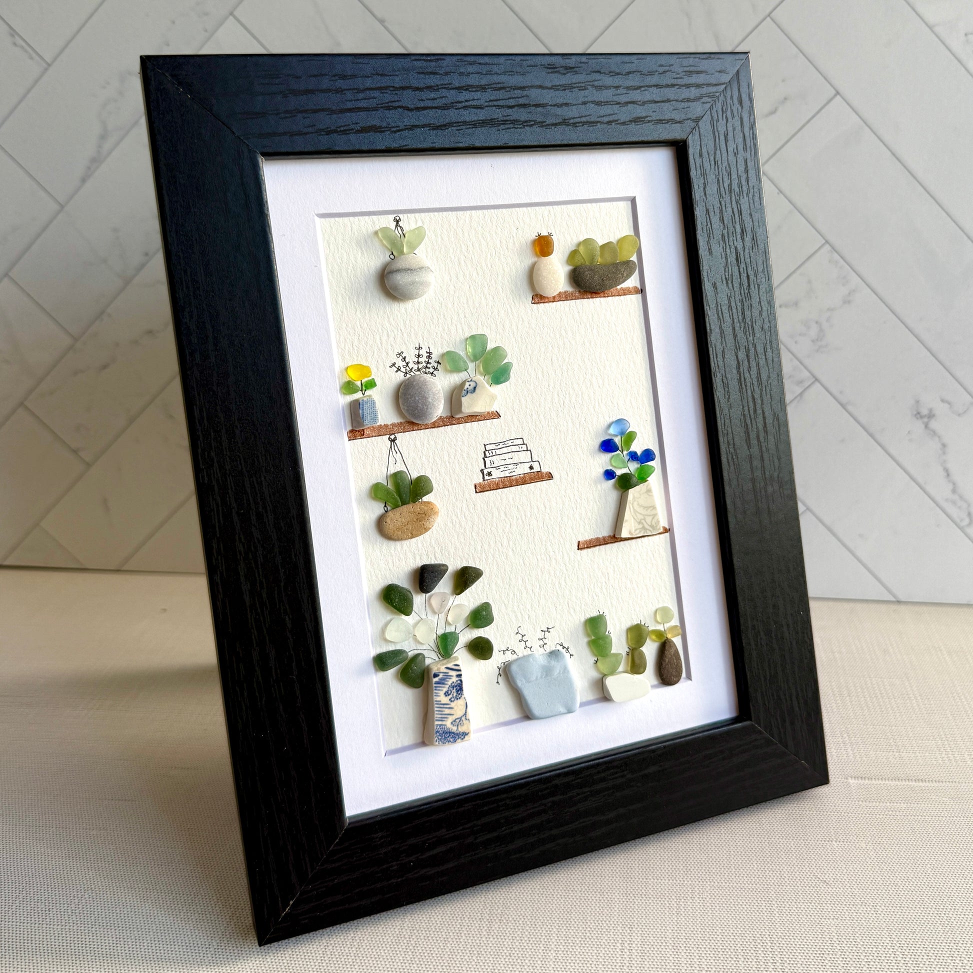 Framed artwork of small plants on a white background