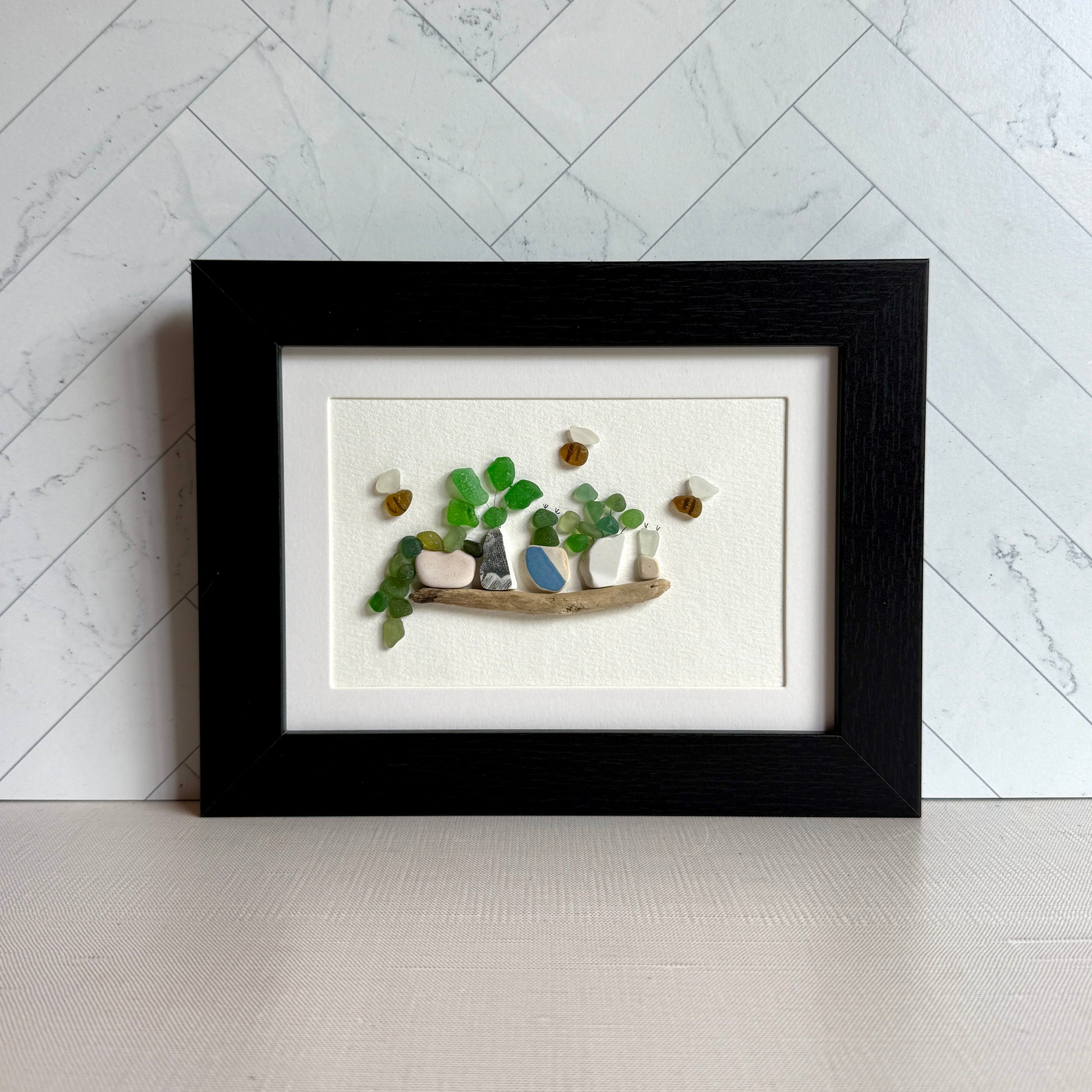 Framed artwork of a garden scene with plants and a bird on a white background