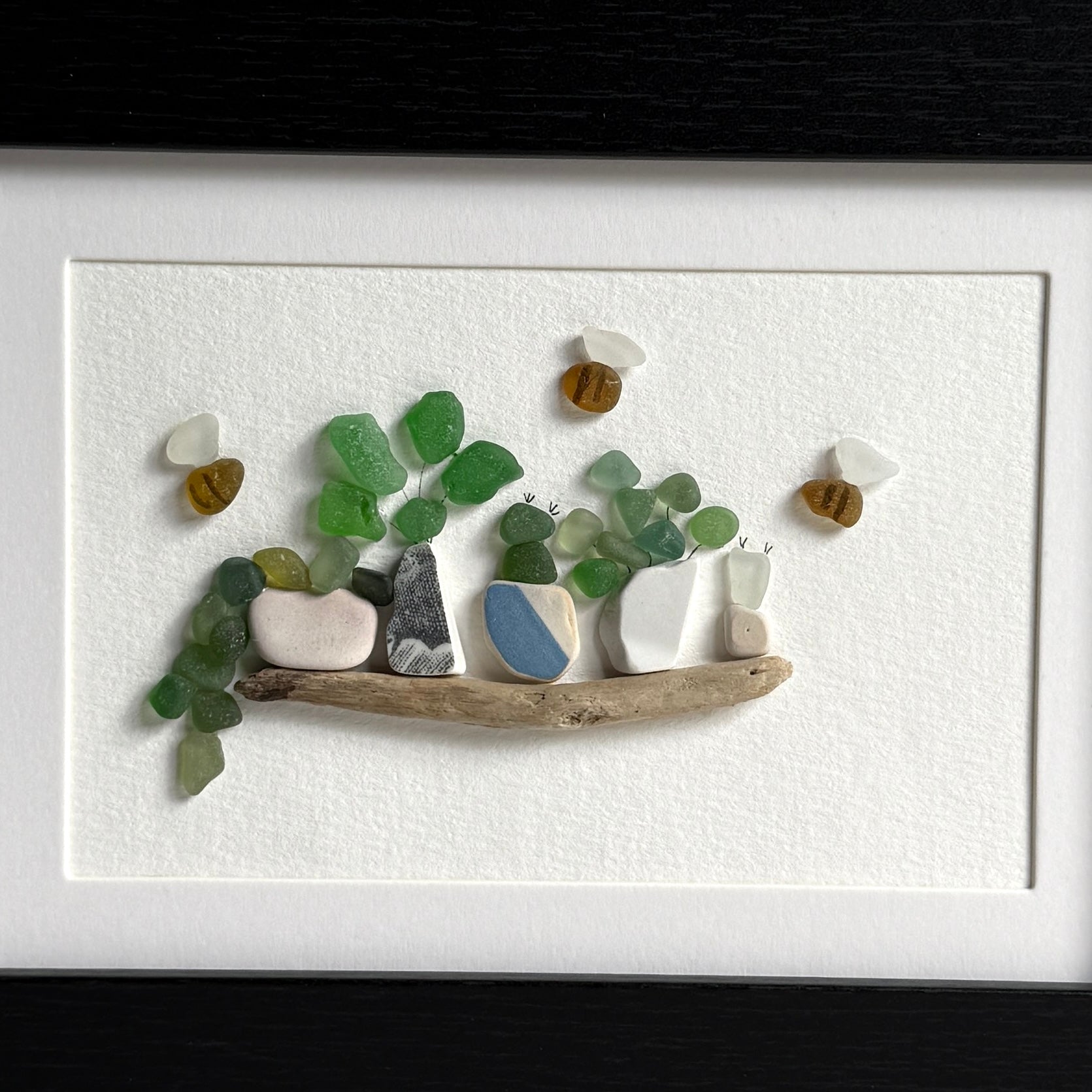 Artistic arrangement of pebbles and driftwood on a white background