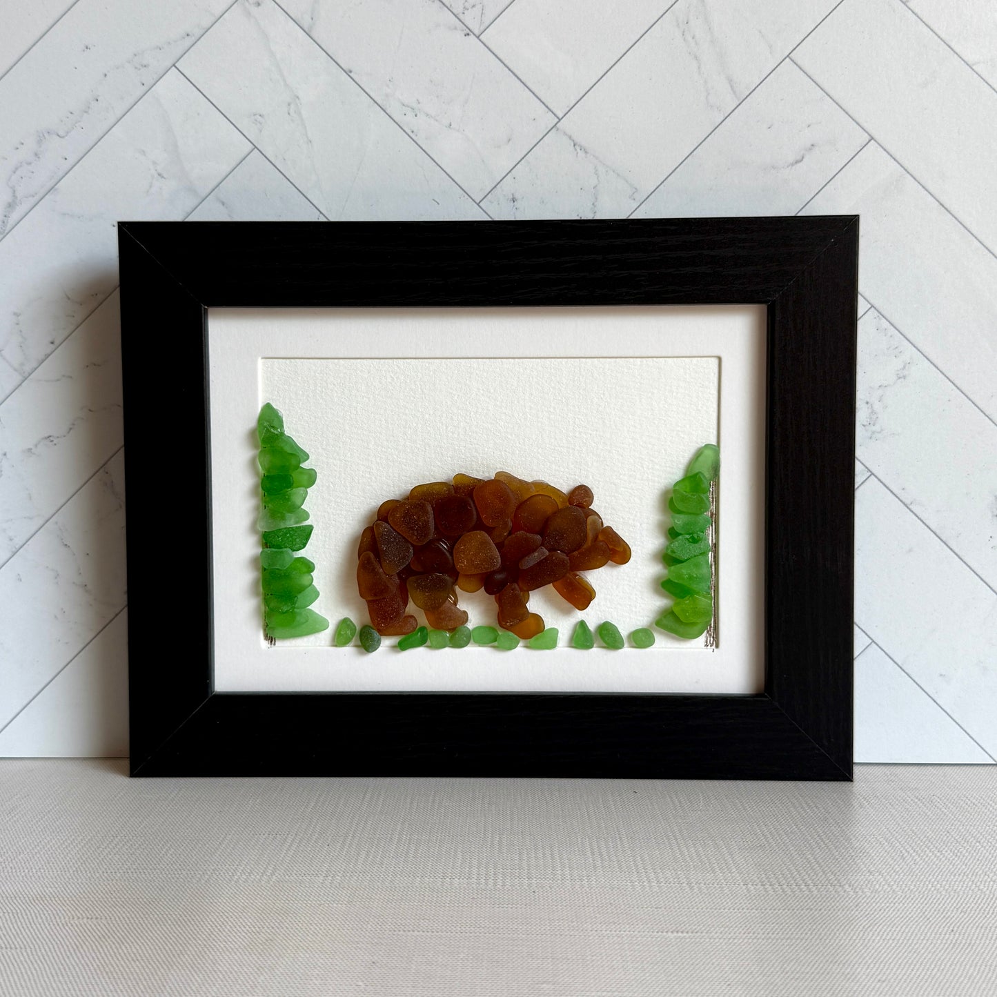 Framed artwork of a bear and trees on a white background