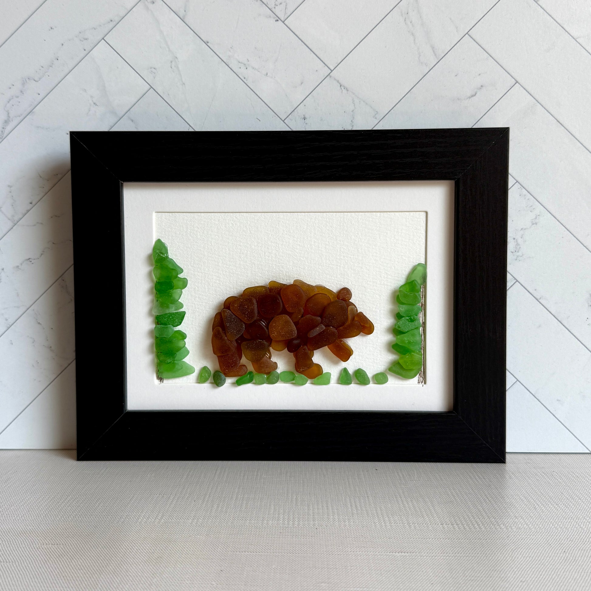 Framed artwork of a bear and trees on a white background