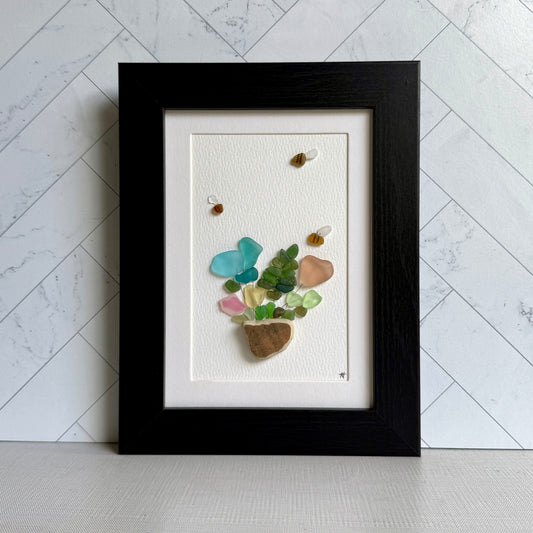 Framed artwork with colorful stones on a white background