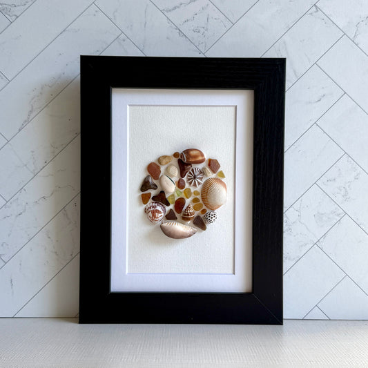 Framed artwork made of seashells on a white background