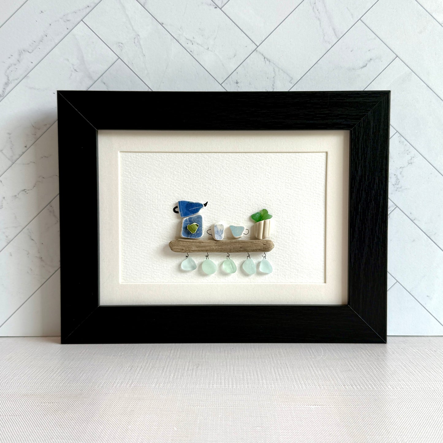 Handmade 5x7 framed sea glass and beach pottery coffee art with moka pot and mugs on driftwood shelf.
