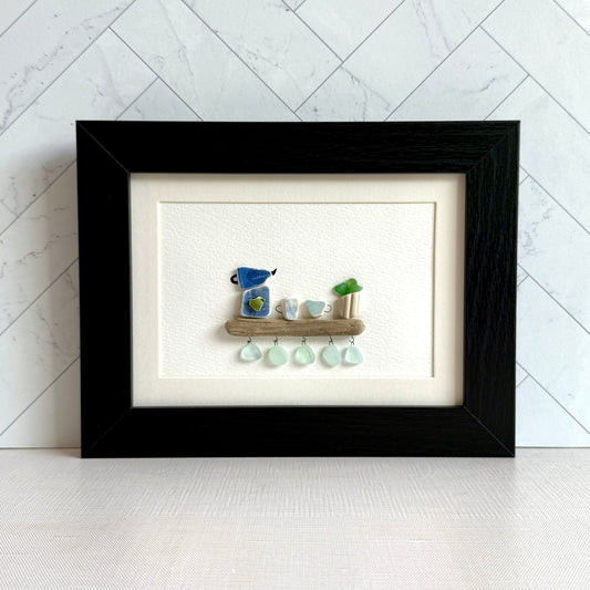 Handmade 5x7 framed sea glass and beach pottery coffee art with moka pot and mugs on driftwood shelf.