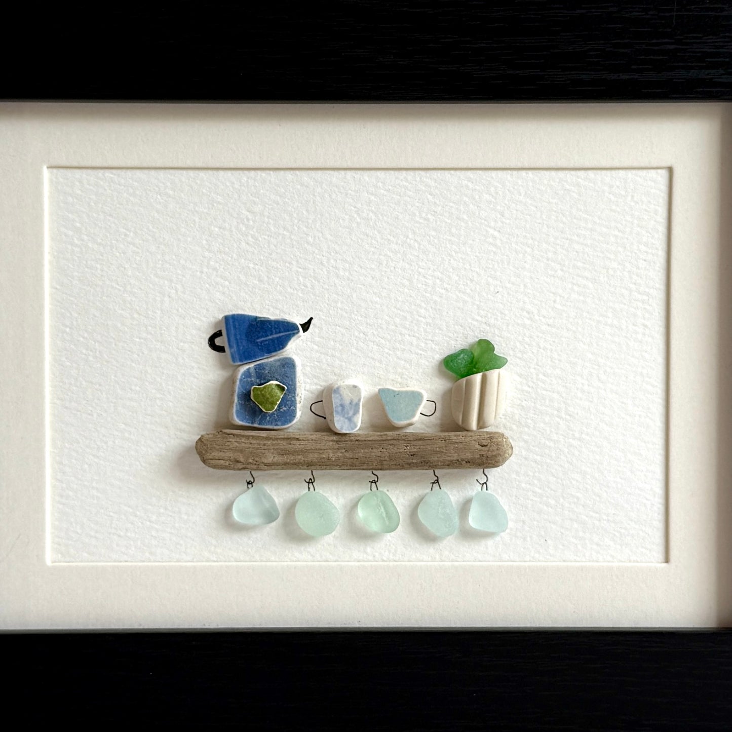 Handmade 5x7 framed sea glass and beach pottery coffee art with moka pot and mugs on driftwood shelf.