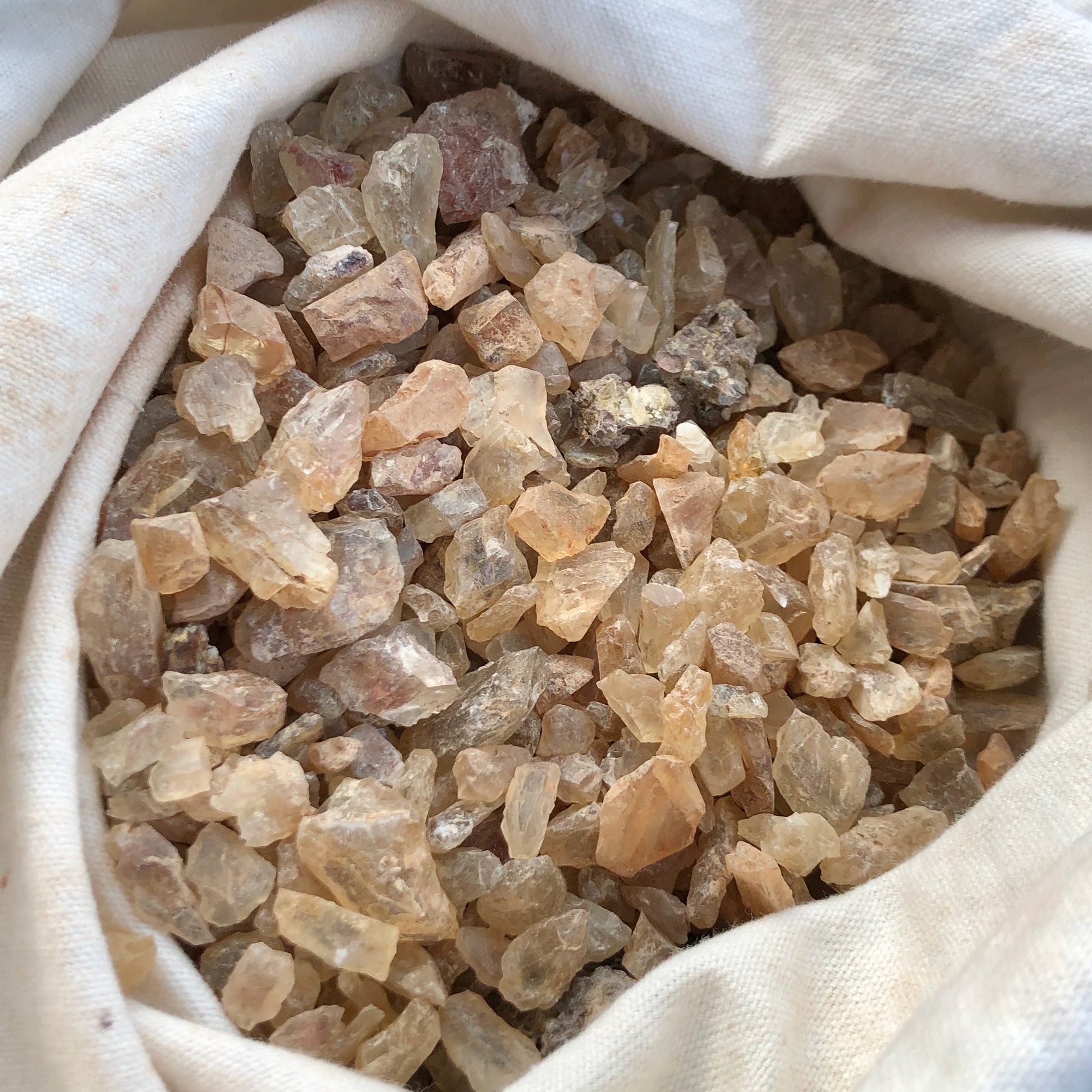 Close-up of rough Oregon sunstones in a white cloth bag